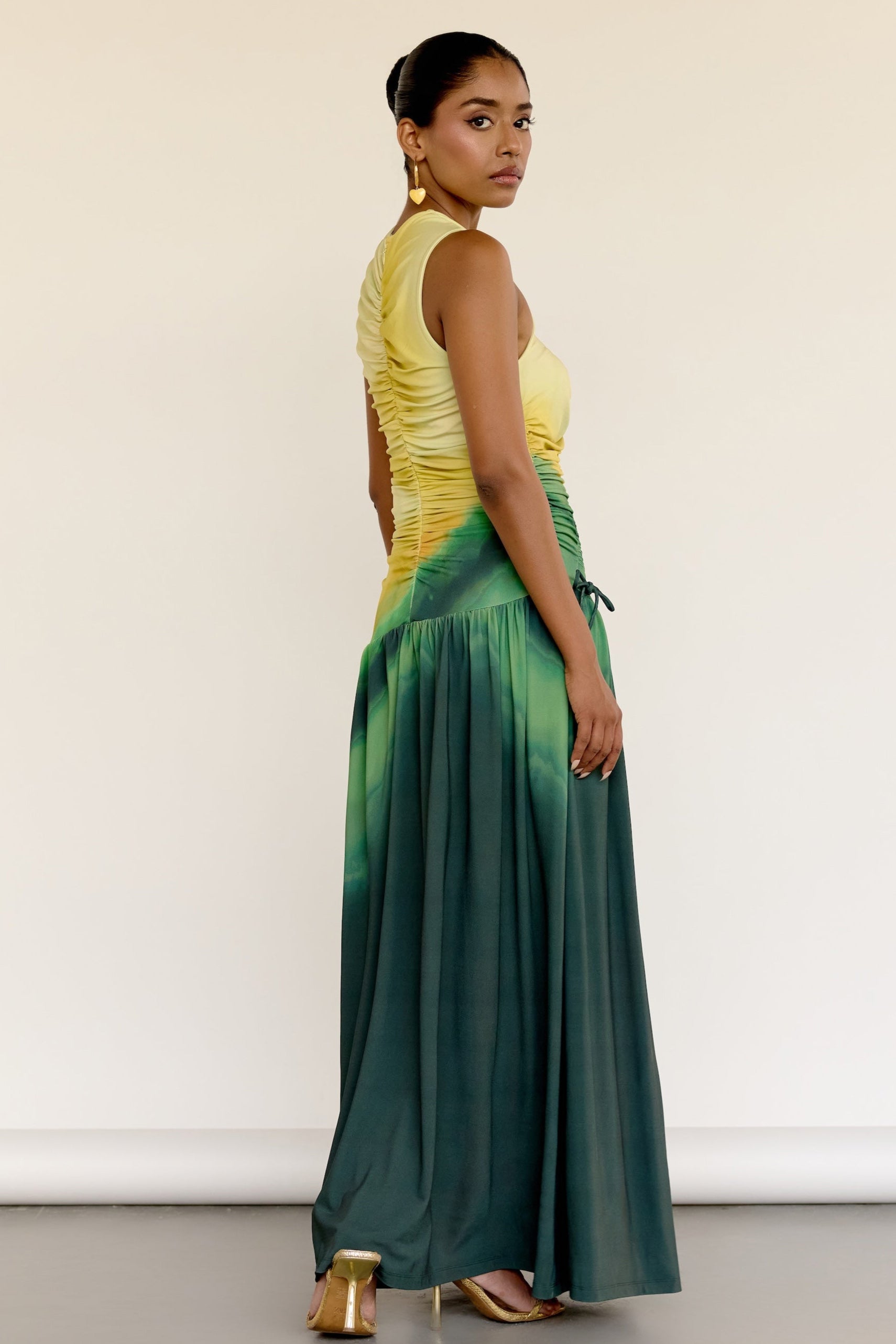 The Ruchi Dress is designed with versatility in mind, featuring a comfortable stretch fabric and an adjustable cinched waist for a customizable fit. The ombré color makes it easy to dress up or down for any occasion.