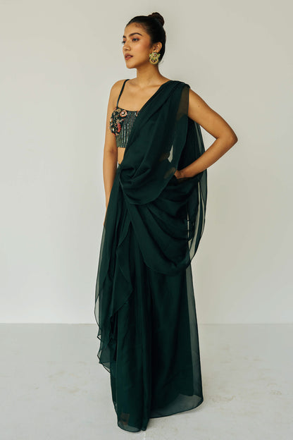 The Adya Drape Saree makes it easy to get the saree look without any pleating and features a shiny organaza skirt with an attached drape + a hand embroidered, bustier top.