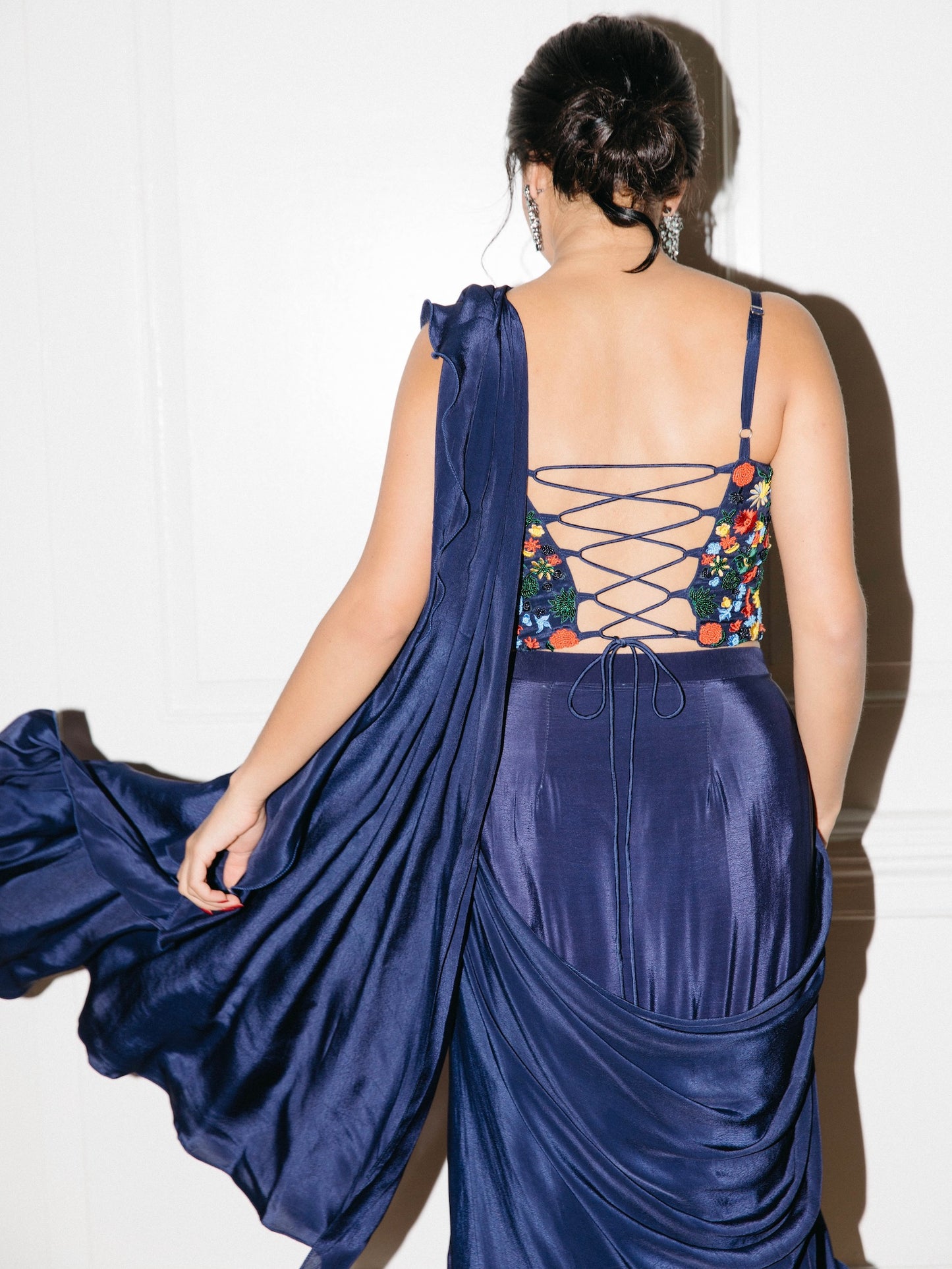 The Ani Corset Drape Saree features our best-selling corset top but with intricate beading work. It is paired back to an attached silky ruffle drape saree.