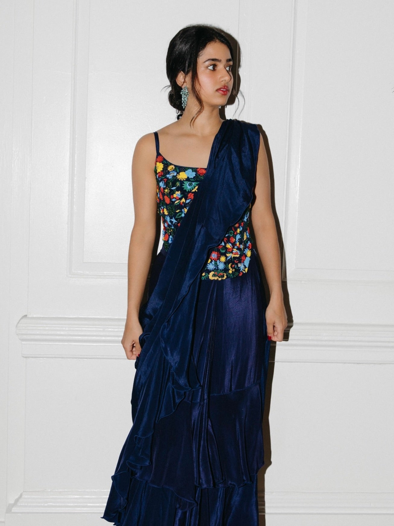 The Ani Corset Drape Saree features our best-selling corset top but with intricate beading work. It is paired back to an attached silky ruffle drape saree.