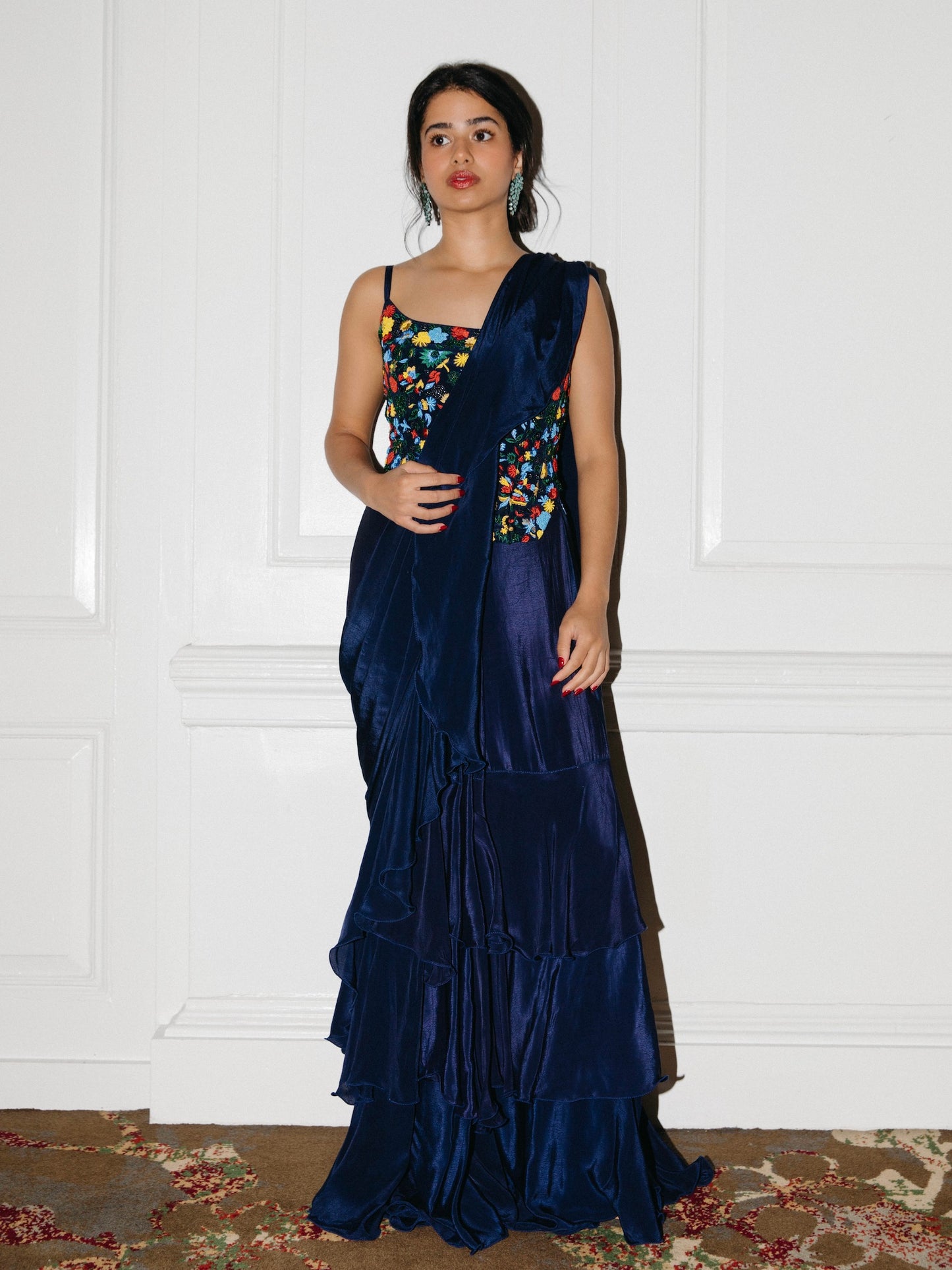 The Ani Corset Drape Saree features our best-selling corset top but with intricate beading work. It is paired back to an attached silky ruffle drape saree.