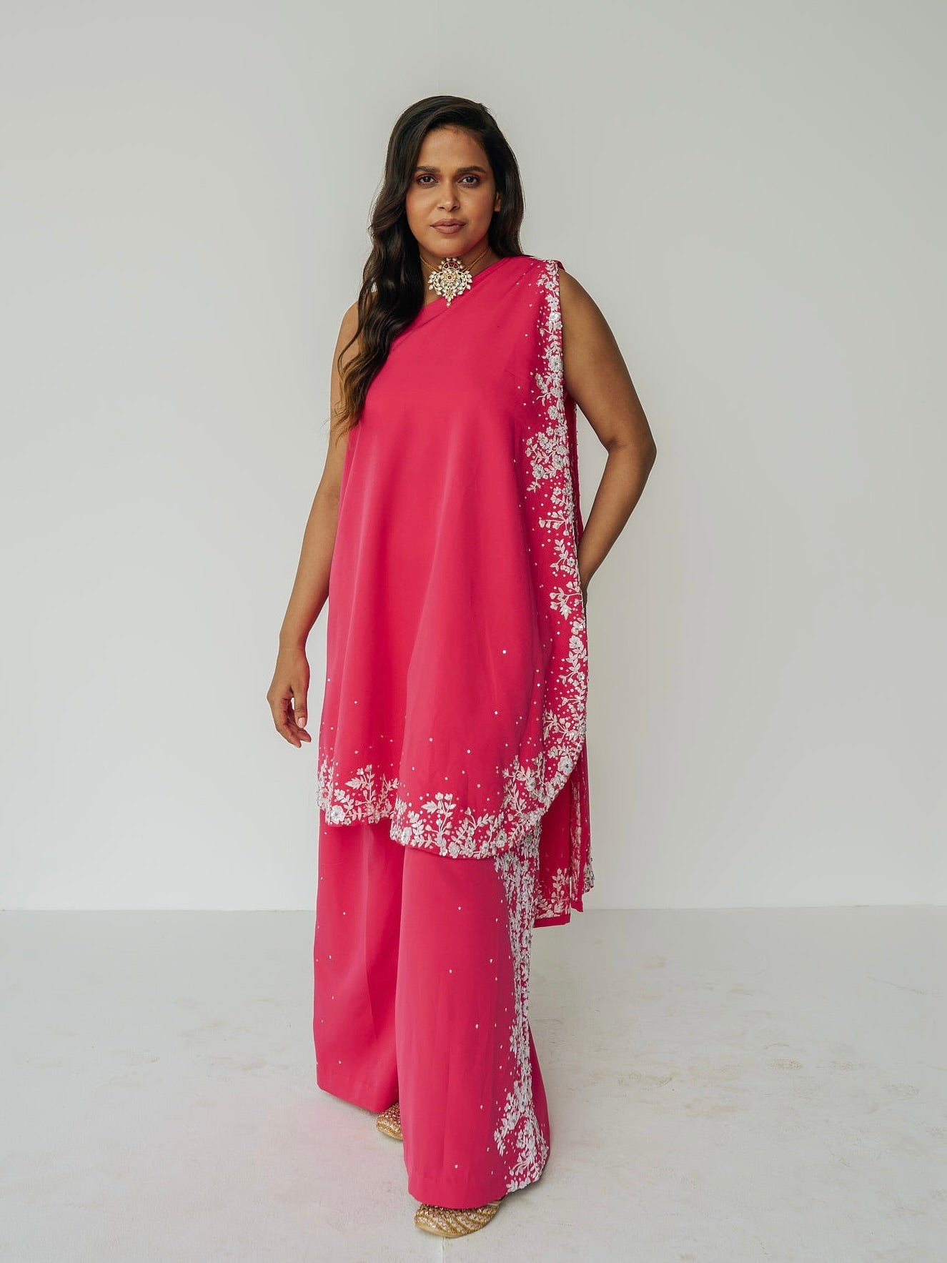 The Cleo Set consists of one shoulder top with hand-embroidered, high-waisted pants, and a detachable drape.
