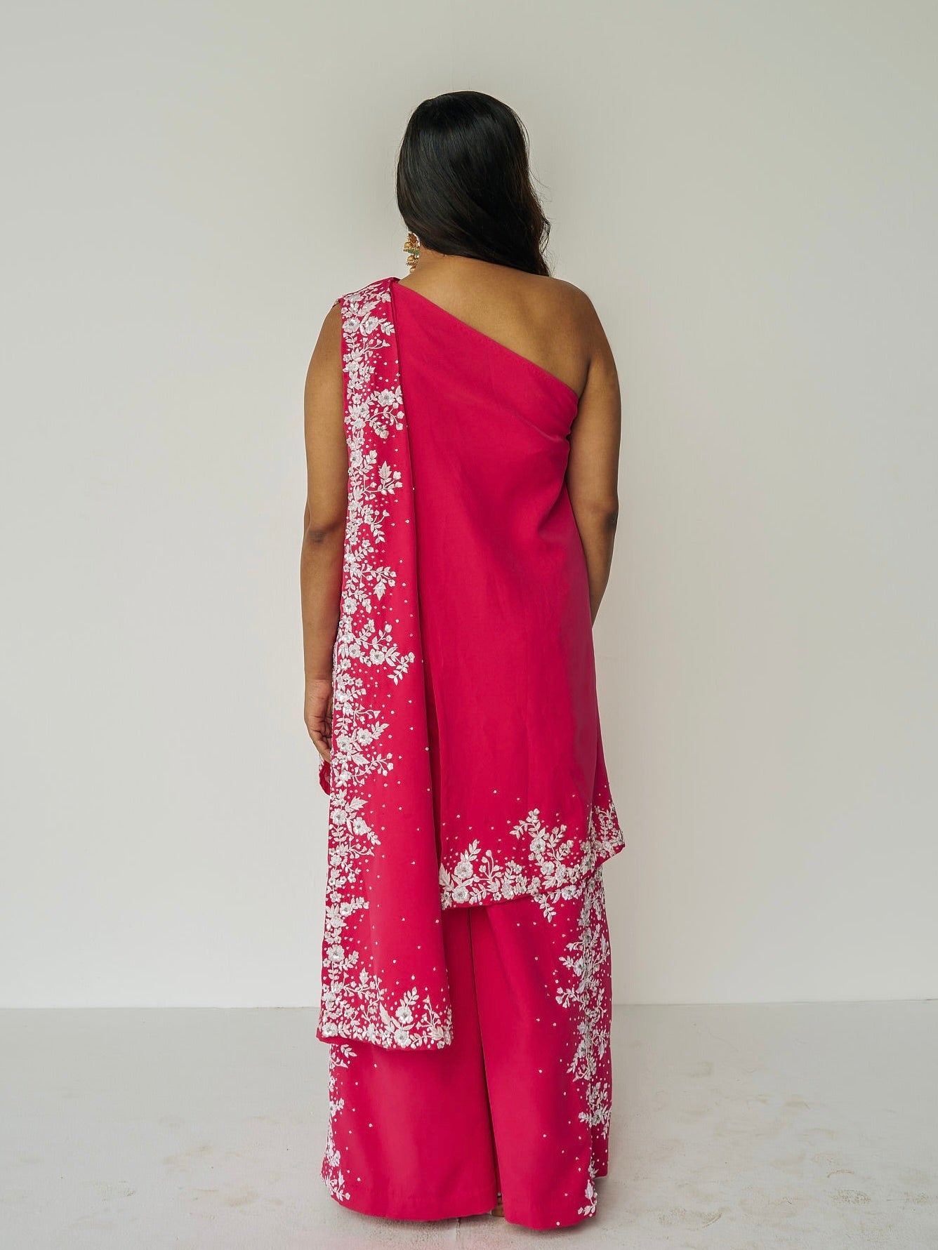 The Cleo Set consists of one shoulder top with hand-embroidered, high-waisted pants, and a detachable drape.