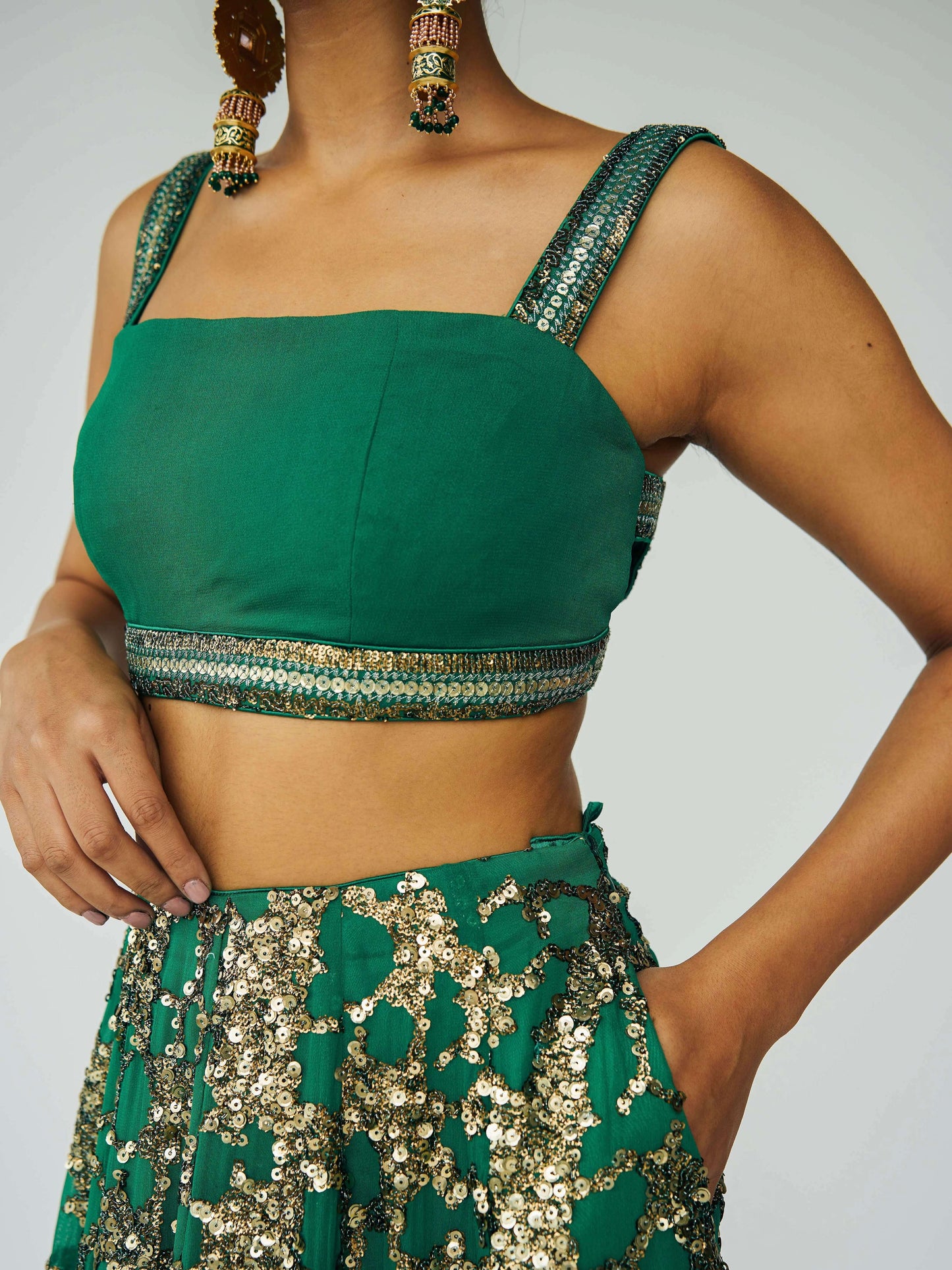 The Detachable Lehenga features a sequin-adorned skirt, criss-cross back blouse, a and delicate net dupatta. With a removable portion, it effortlessly transforms into a shorter skirt for a night of dancing.