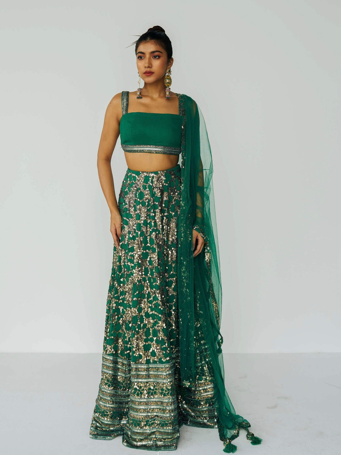The Detachable Lehenga features a sequin-adorned skirt, criss-cross back blouse, a and delicate net dupatta. With a removable portion, it effortlessly transforms into a shorter skirt for a night of dancing.