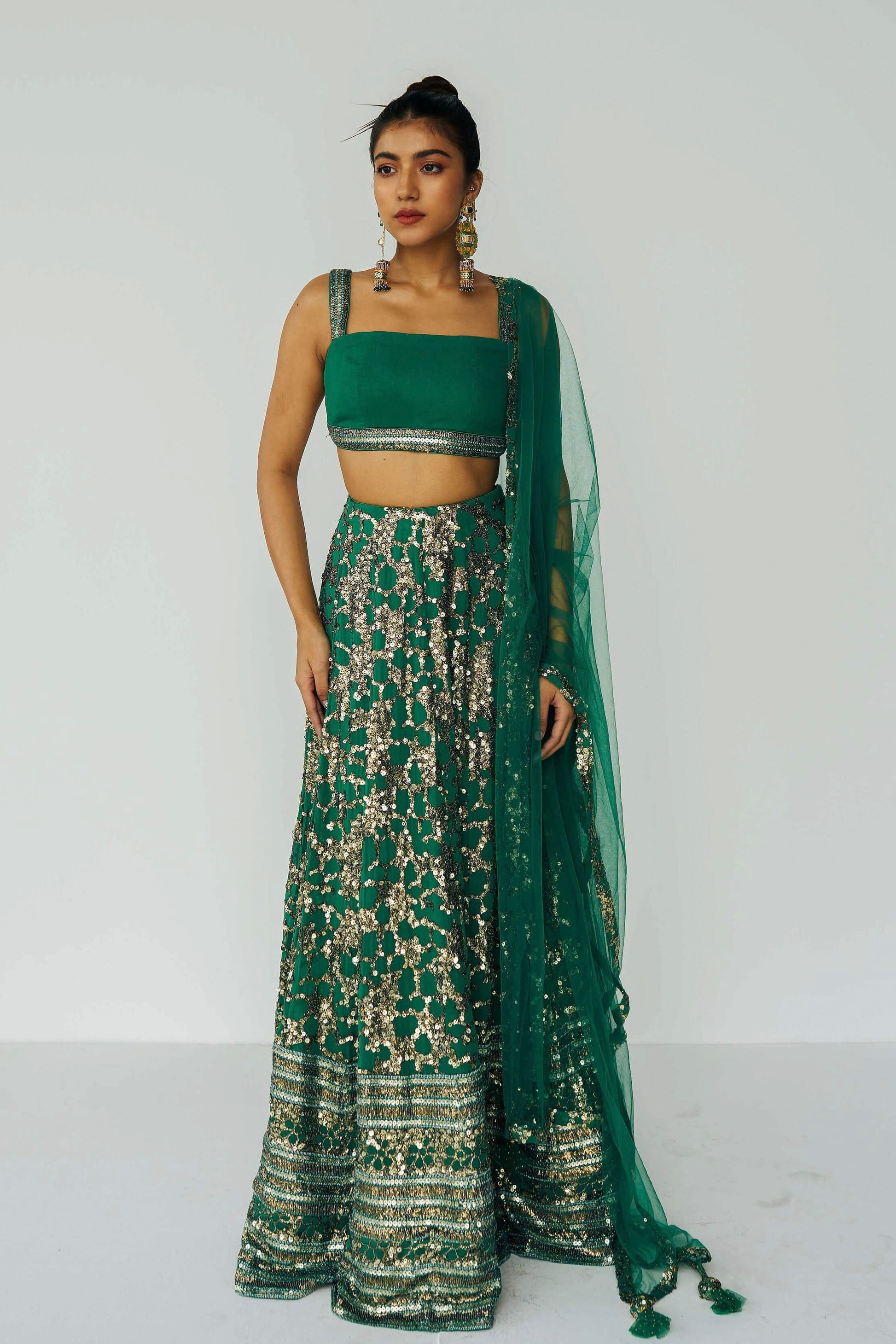 The Detachable Lehenga features a sequin-adorned skirt, criss-cross back blouse, a and delicate net dupatta. With a removable portion, it effortlessly transforms into a shorter skirt for a night of dancing.