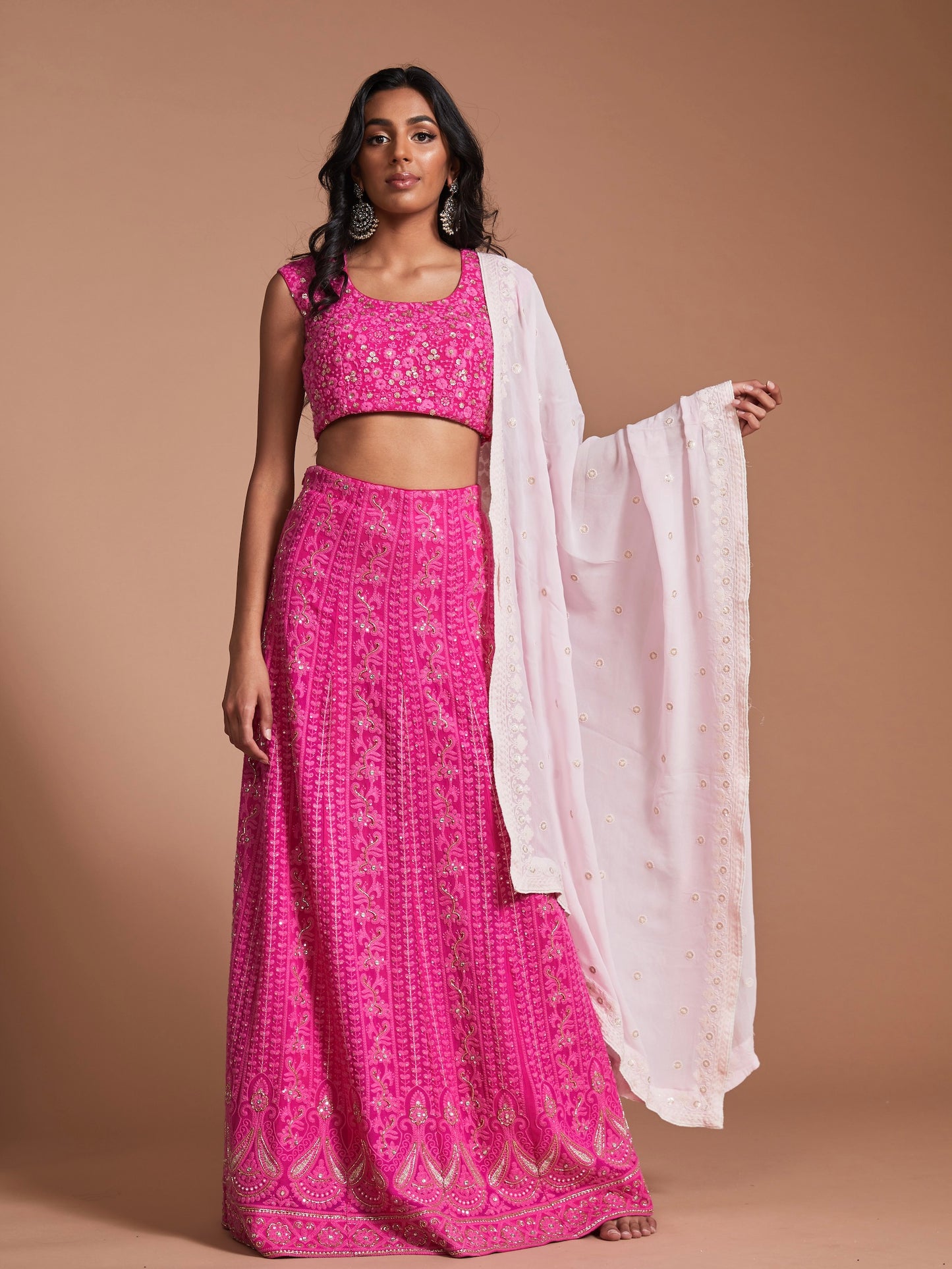 The Ishita Lehenga is a bright pink lucknowi (also known as chikankari) georgette skirt, a matching cap sleeve blouse and is paired with an off-white georgette dupatta.