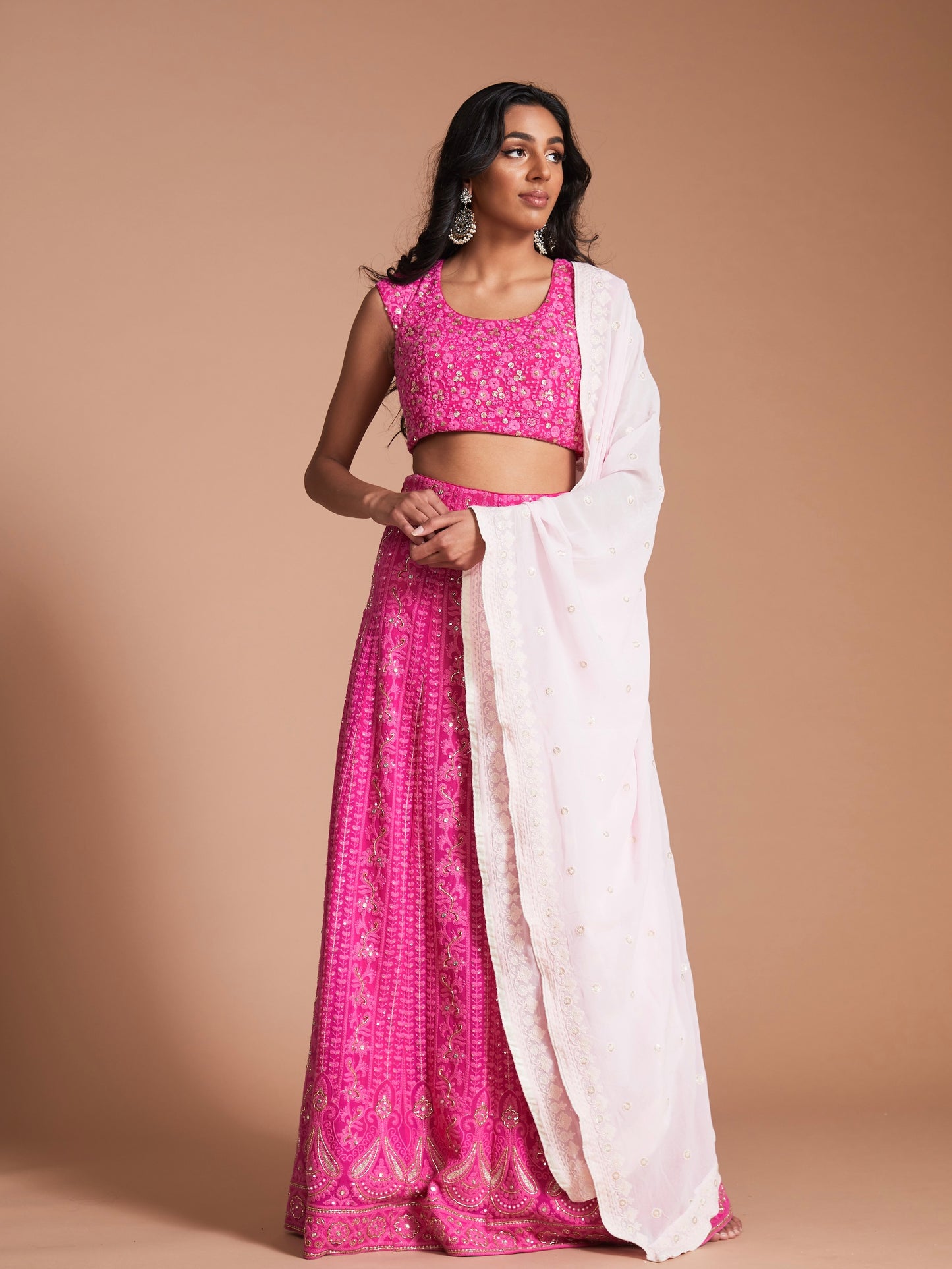 The Ishita Lehenga is a bright pink lucknowi (also known as chikankari) georgette skirt, a matching cap sleeve blouse and is paired with an off-white georgette dupatta.