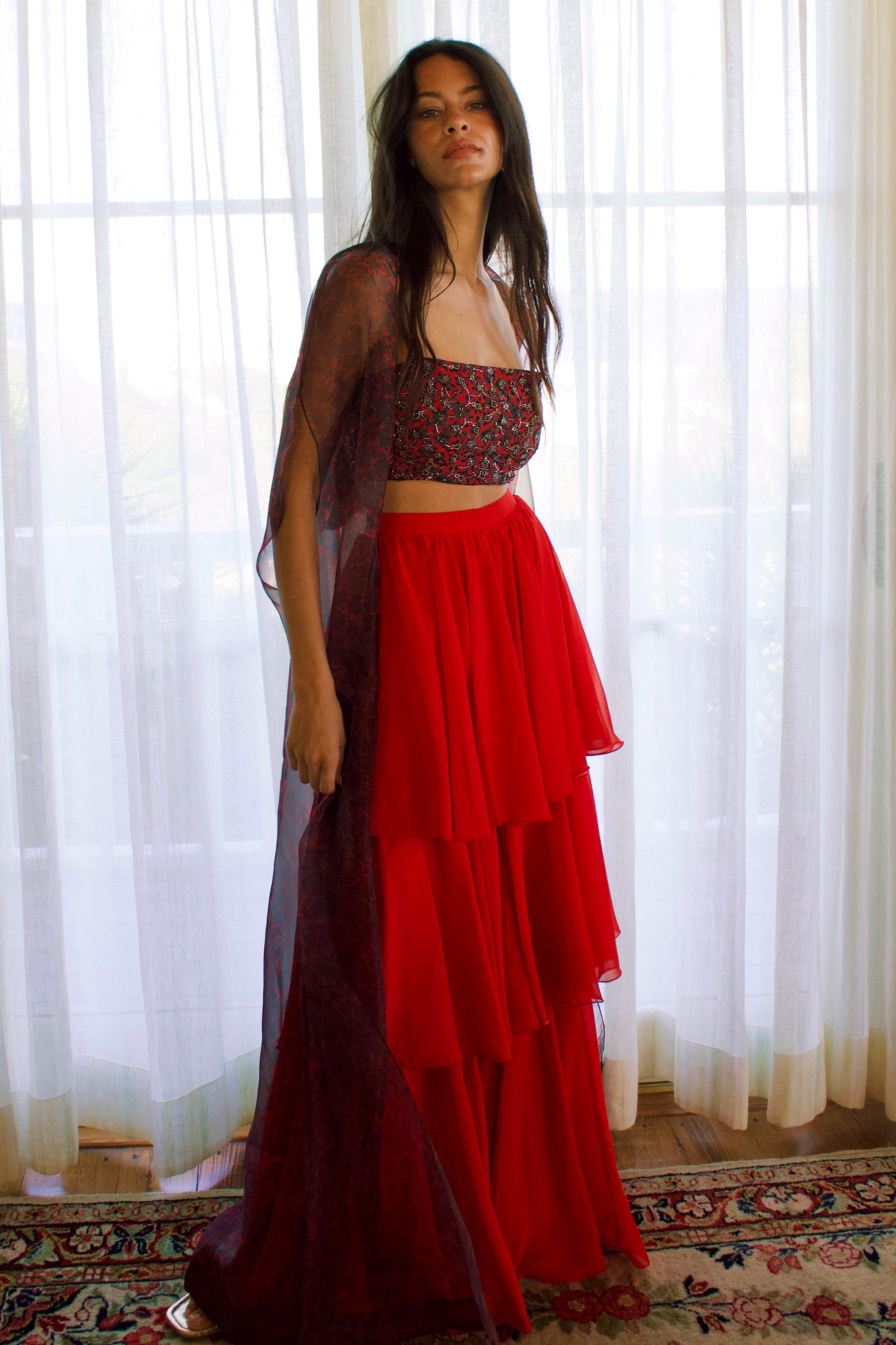 The Mirza Outfit includes a fully hand-beaded blouse with adjustable straps, tiered flared pants that add movement, and a sheer organza cape you’ll want to wear long after the event.