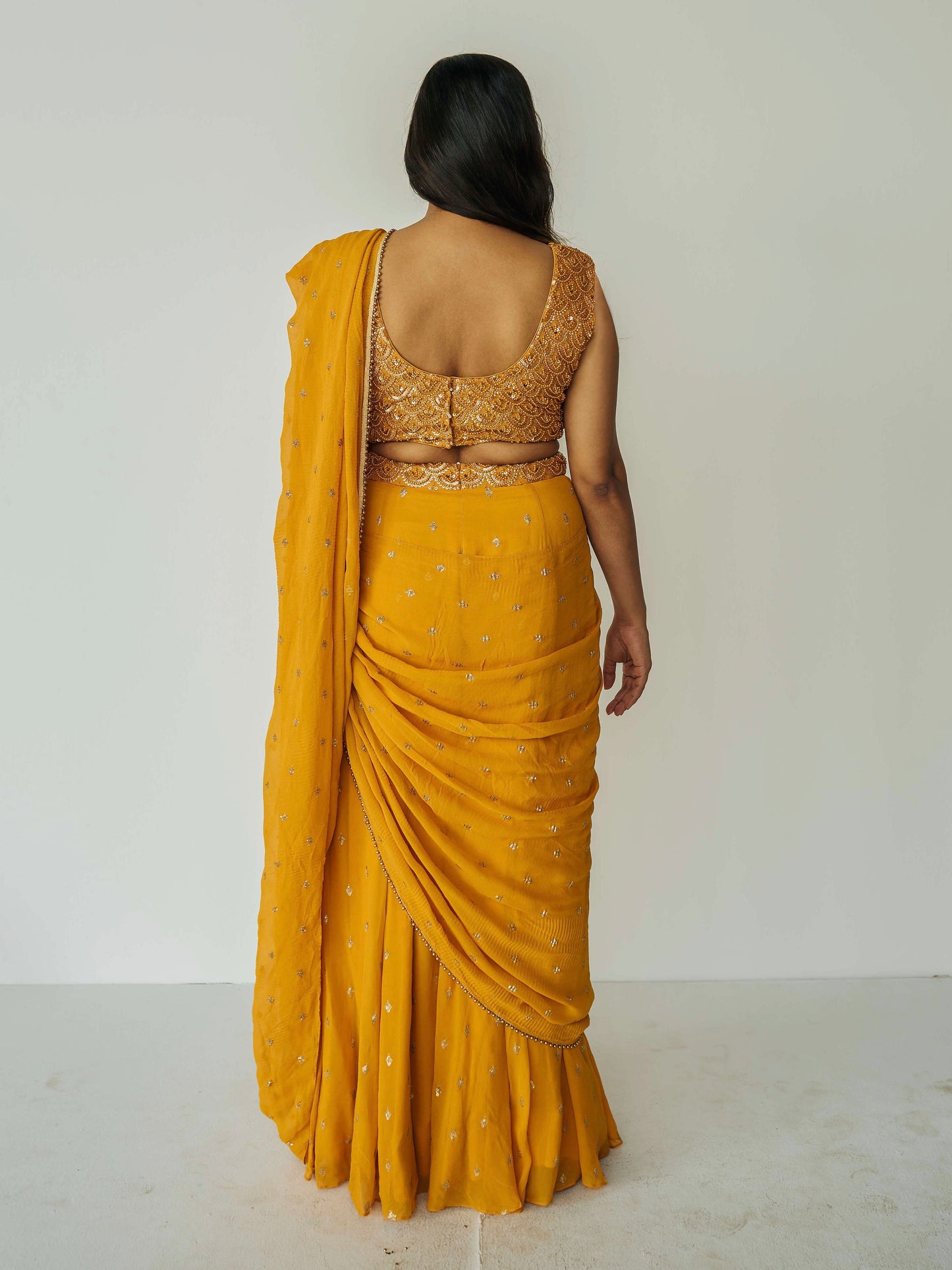 The Rani Palazzo 2.0 gives you the drape of a saree without any hassle. Featuring an all over embroidery on the pants and drape, and the blouse includes sequin work with accent beading.