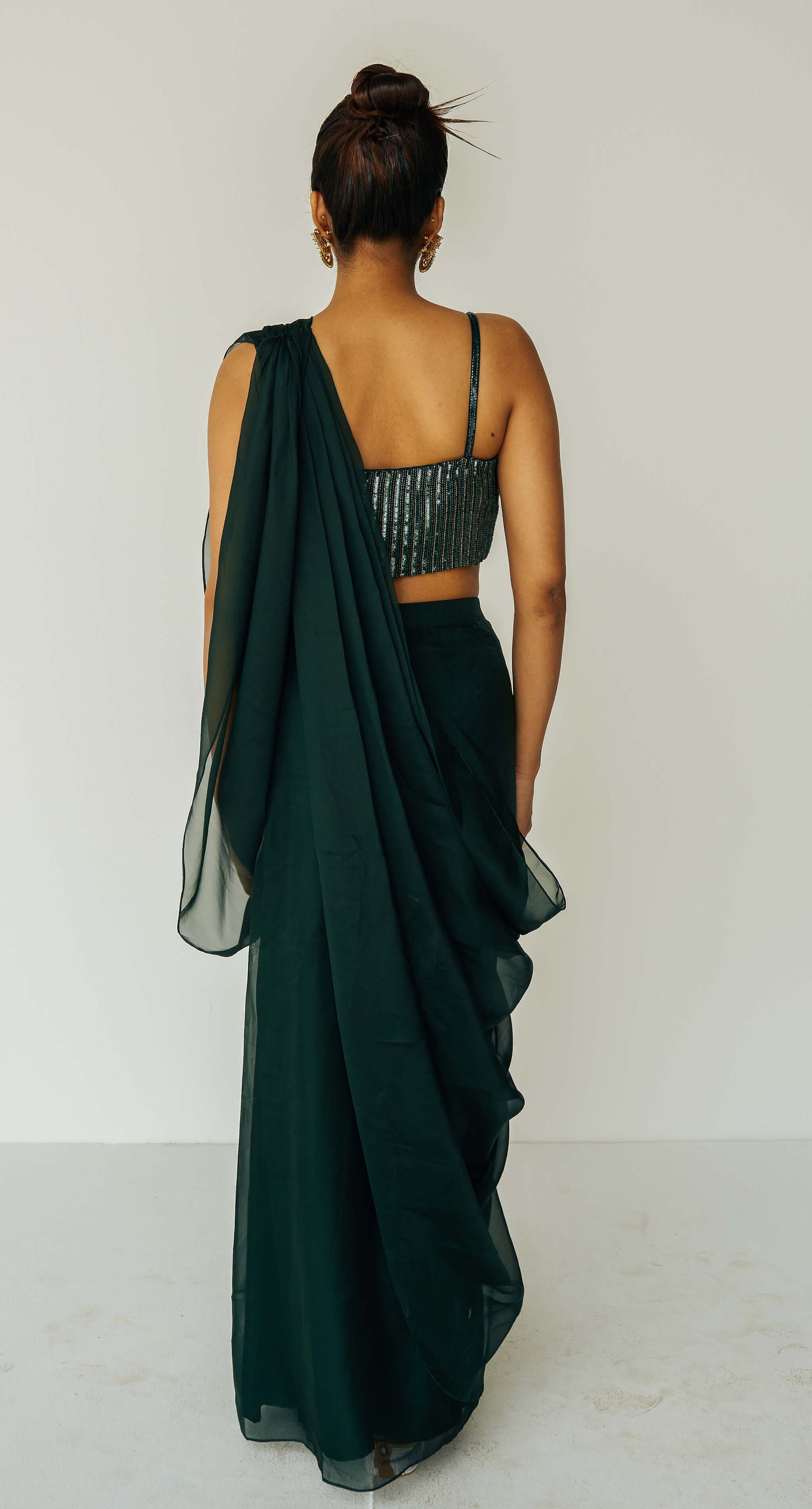 The Adya Drape Saree makes it easy to get the saree look without any pleating and features a shiny organaza skirt with an attached drape + a hand embroidered, bustier top.