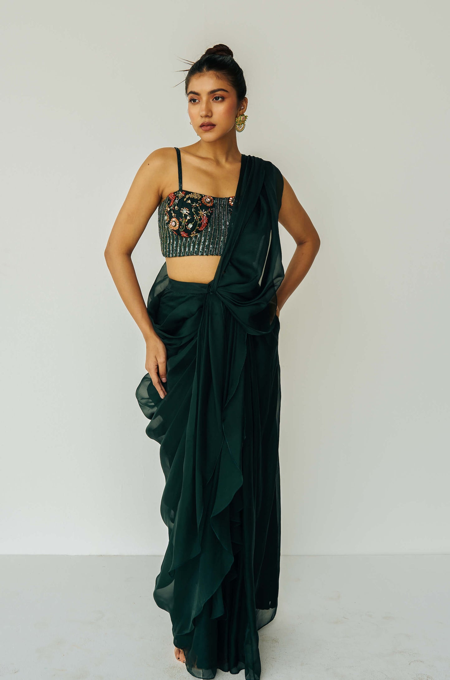 The Adya Drape Saree makes it easy to get the saree look without any pleating and features a shiny organaza skirt with an attached drape + a hand embroidered, bustier top.