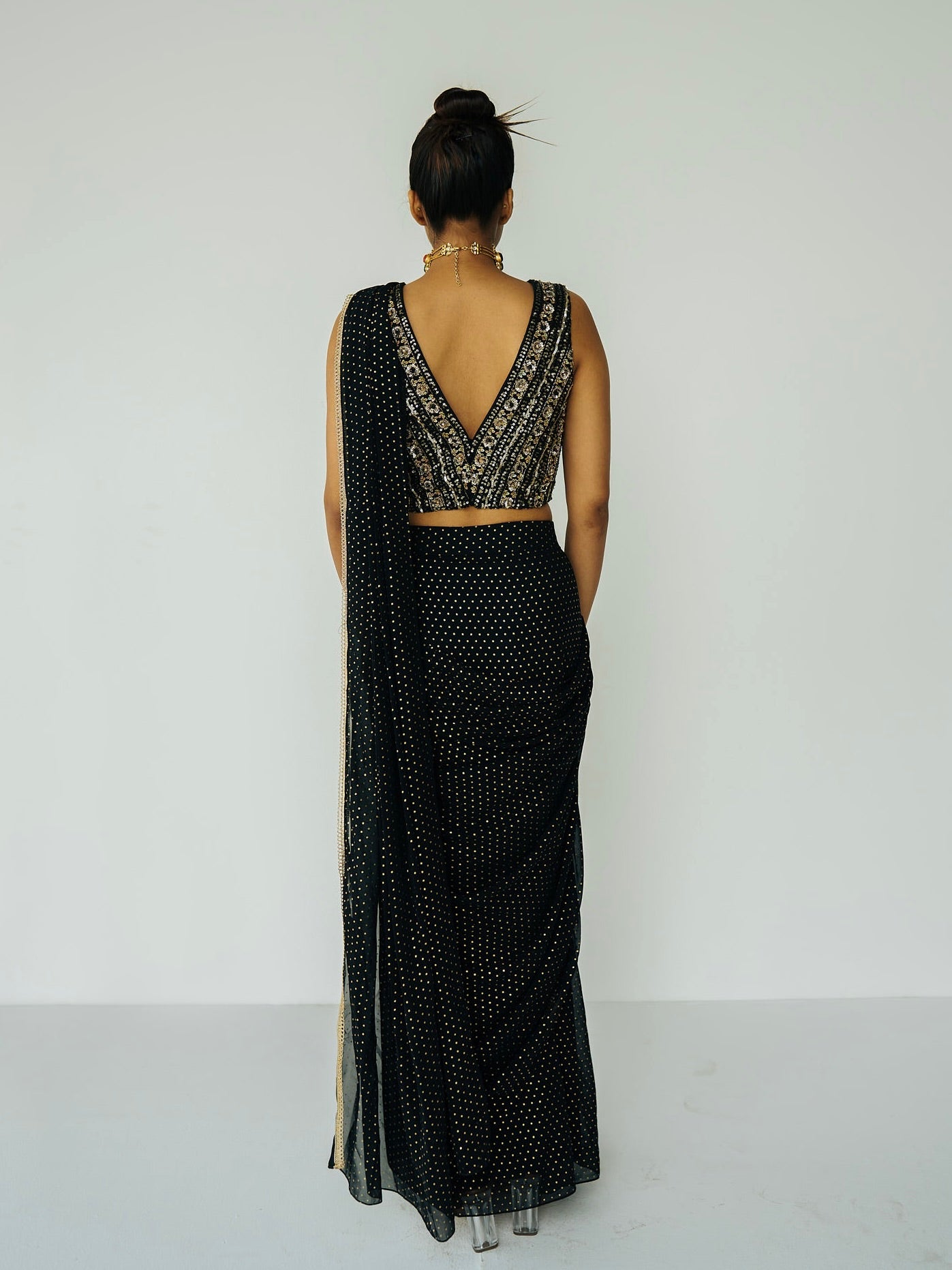 This outfit features a skirt with attached wrap-around draping - all pre-stitched so you can put the outfit together in 30 seconds or less. The drape has small gold embellishments throughout and the piece is paired with a gold hand-embroidered v-neck blouse.
