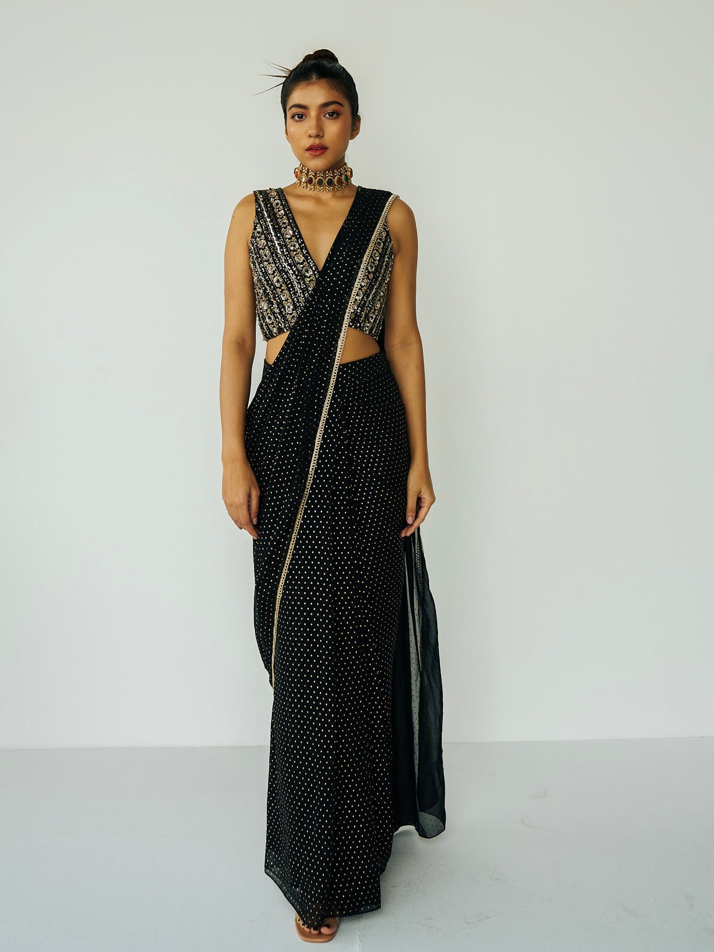This outfit features a skirt with attached wrap-around draping - all pre-stitched so you can put the outfit together in 30 seconds or less. The drape has small gold embellishments throughout and the piece is paired with a gold hand-embroidered v-neck blouse.