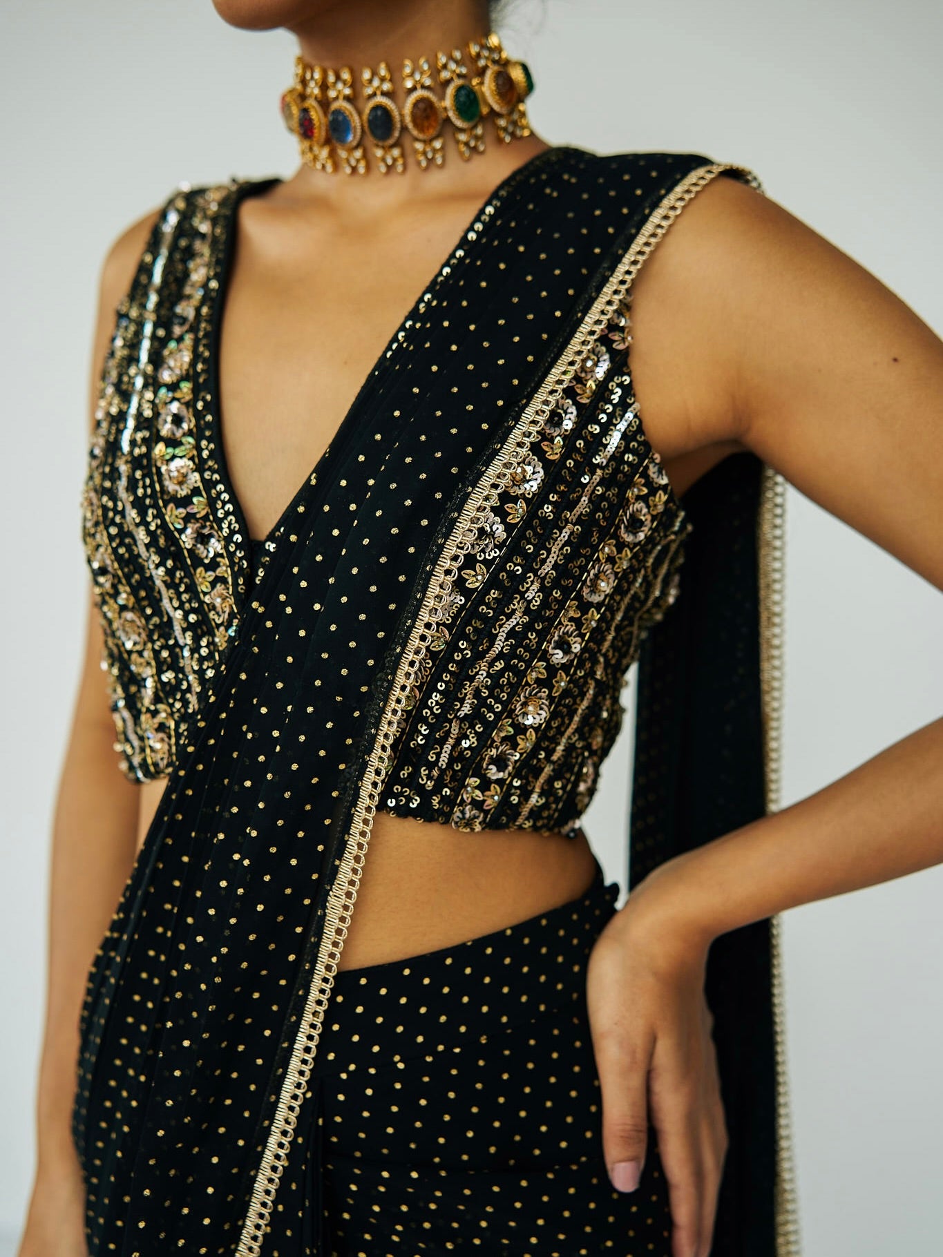 This outfit features a skirt with attached wrap-around draping - all pre-stitched so you can put the outfit together in 30 seconds or less. The drape has small gold embellishments throughout and the piece is paired with a gold hand-embroidered v-neck blouse.