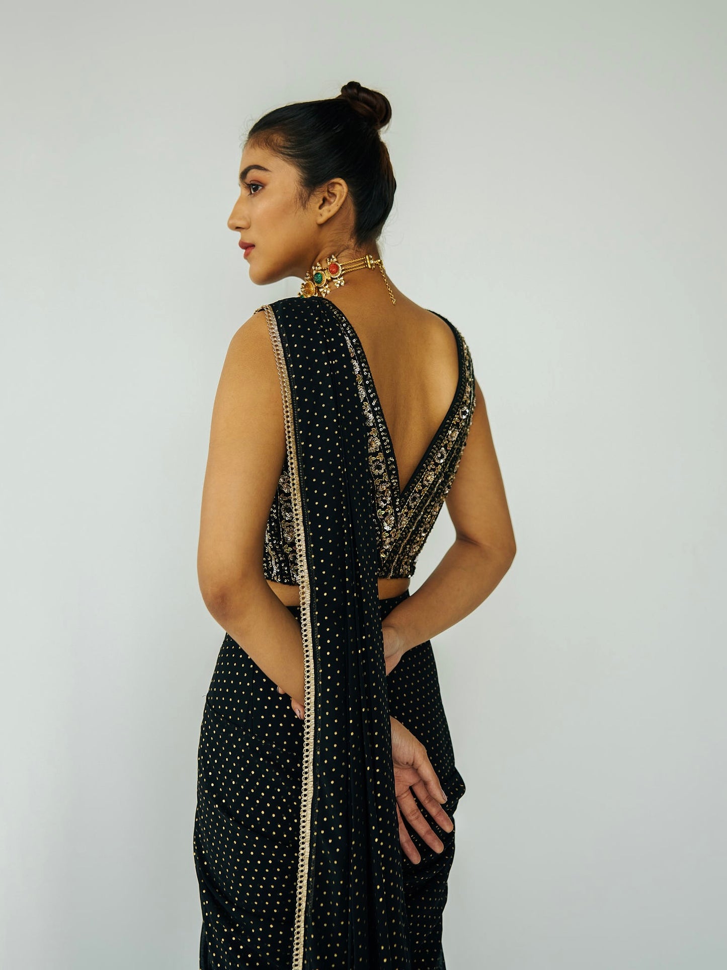 This outfit features a skirt with attached wrap-around draping - all pre-stitched so you can put the outfit together in 30 seconds or less. The drape has small gold embellishments throughout and the piece is paired with a gold hand-embroidered v-neck blouse.