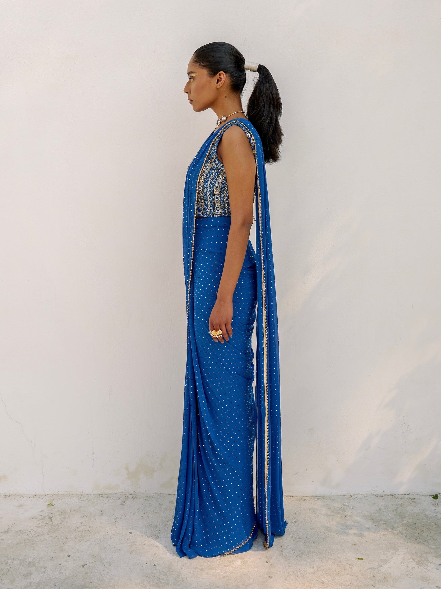 This outfit features a skirt with attached wrap-around draping - all pre-stitched so you can put the outfit together in 30 seconds or less. The drape has small gold embellishments throughout and the piece is paired with a gold hand-embroidered v-neck blouse.