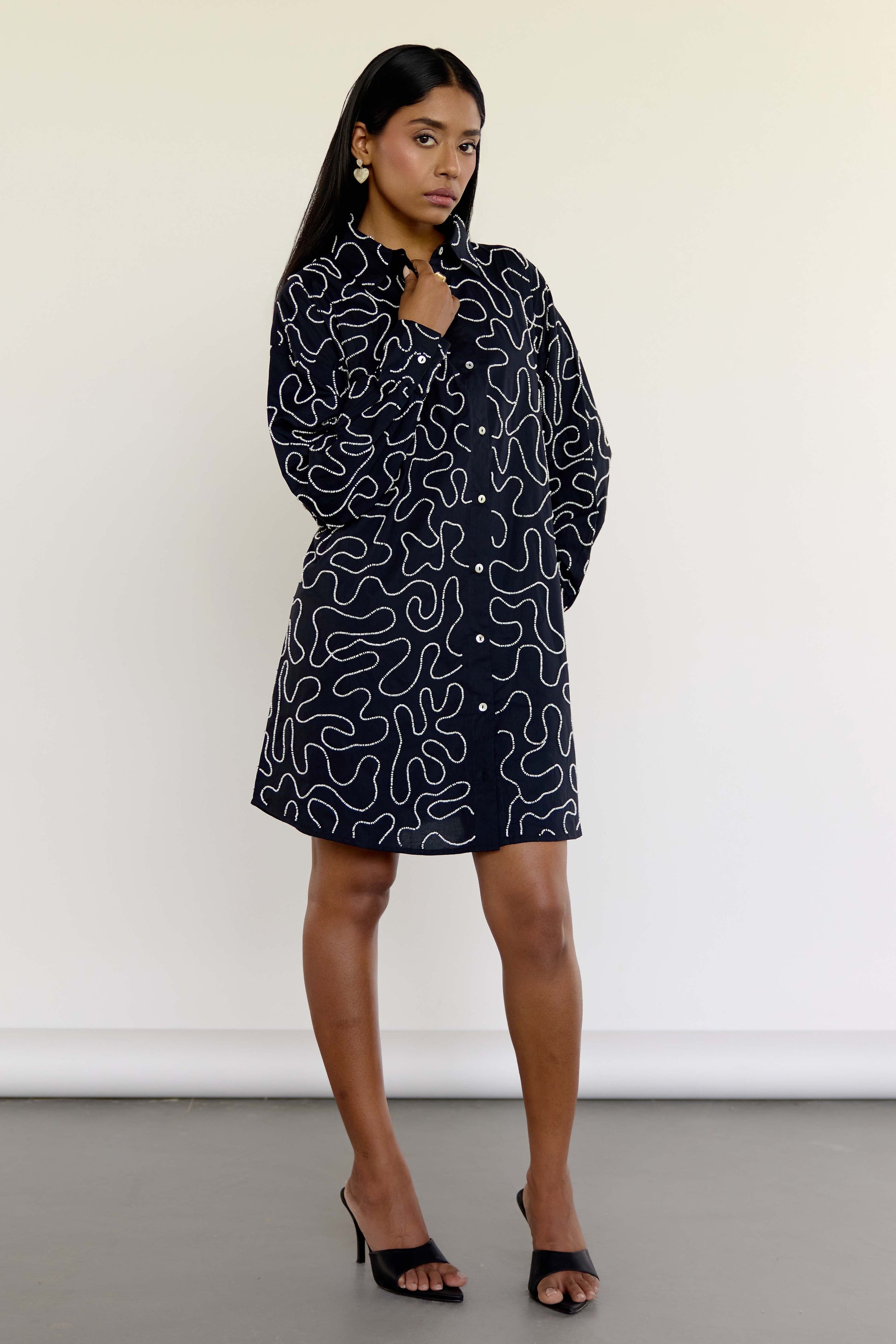 The Kira Dress is our twist on the classic shirt dress—tailored in silhouette but detailed with winding threadwork and subtle beading for just the right amount of drama. Made from soft 100% cotton and finished with contrast buttons, it's the kind of dress that works just as well with sneakers as it does with heels.