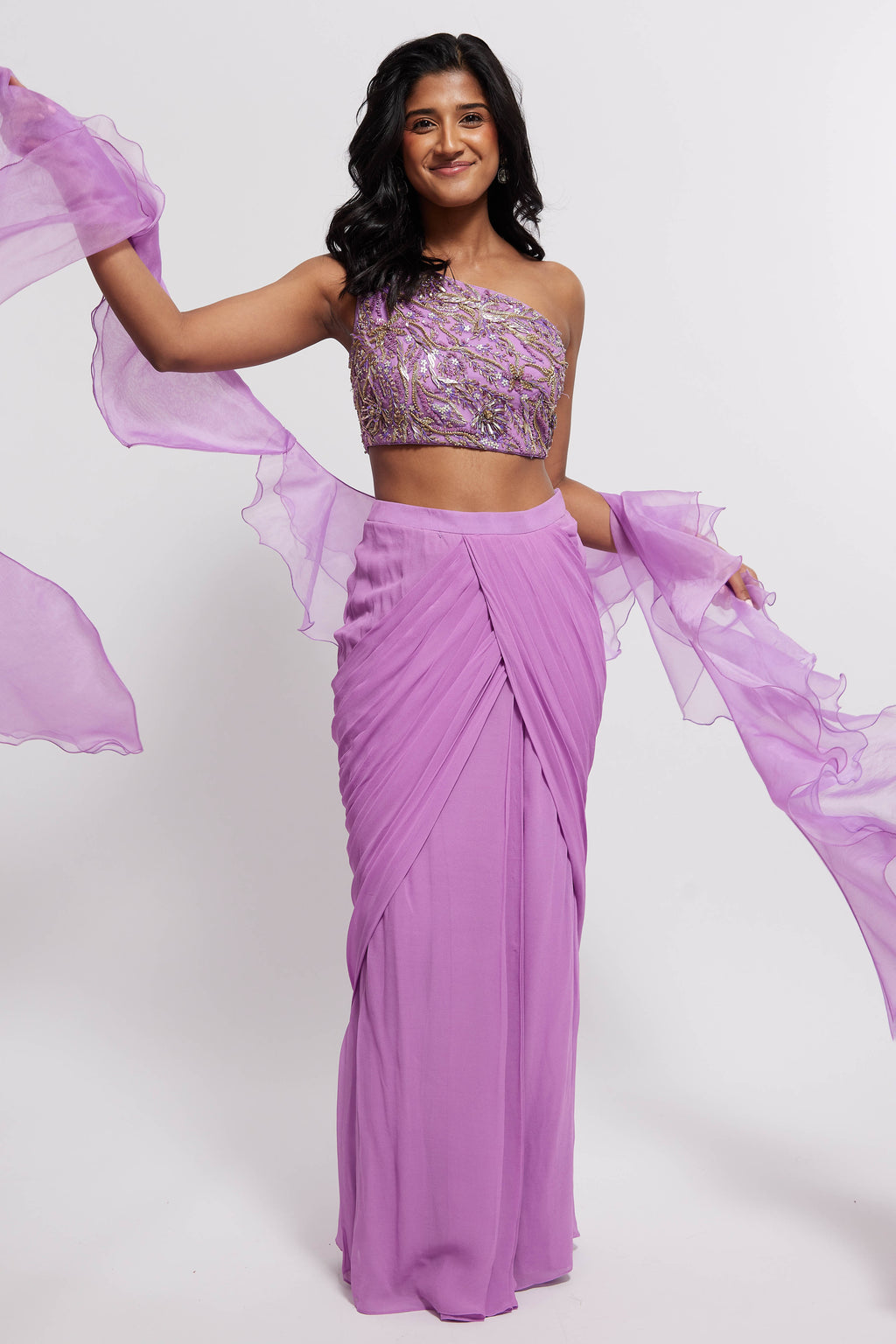 The Aria Ruffle Set features a hand embroidered one-shoulder blouse and pleated skirt that is paired back to a ruffled dupatta.