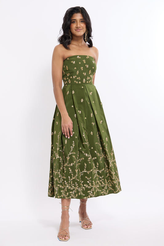 Woman wearing green midi length dress with Indian inspired embroidery