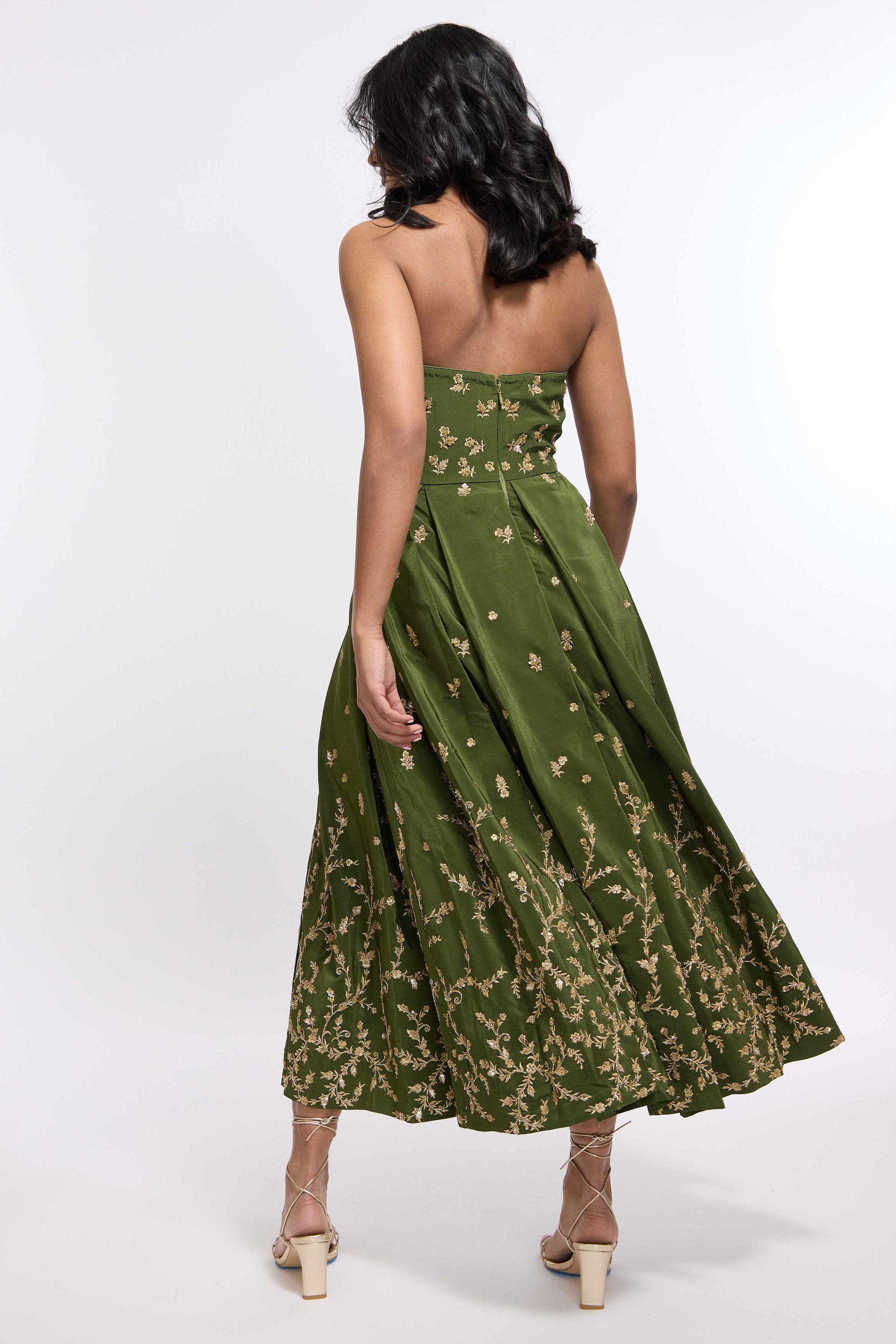 Woman wearing green midi length dress with Indian inspired embroidery