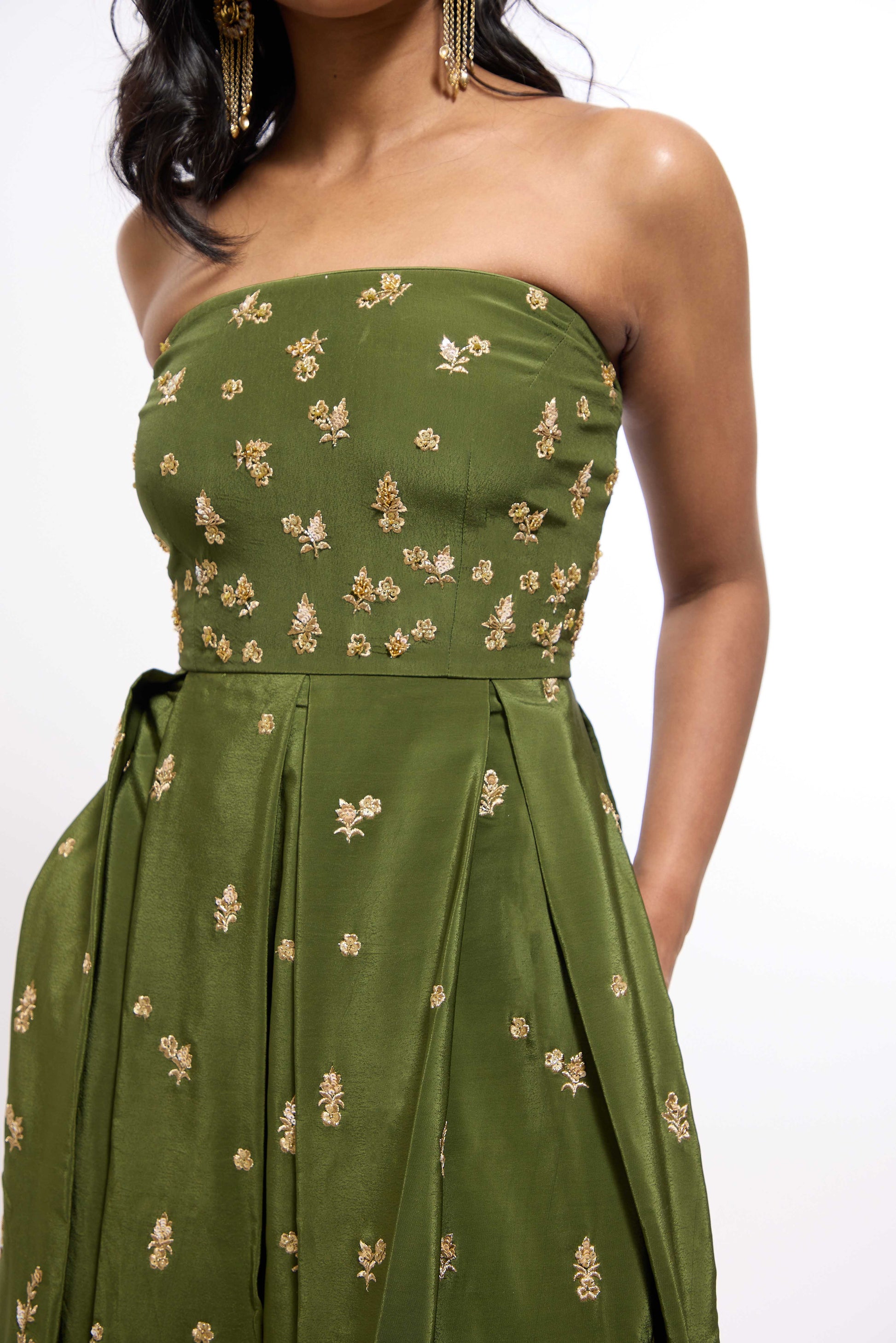 Woman wearing green midi length dress with Indian inspired embroidery