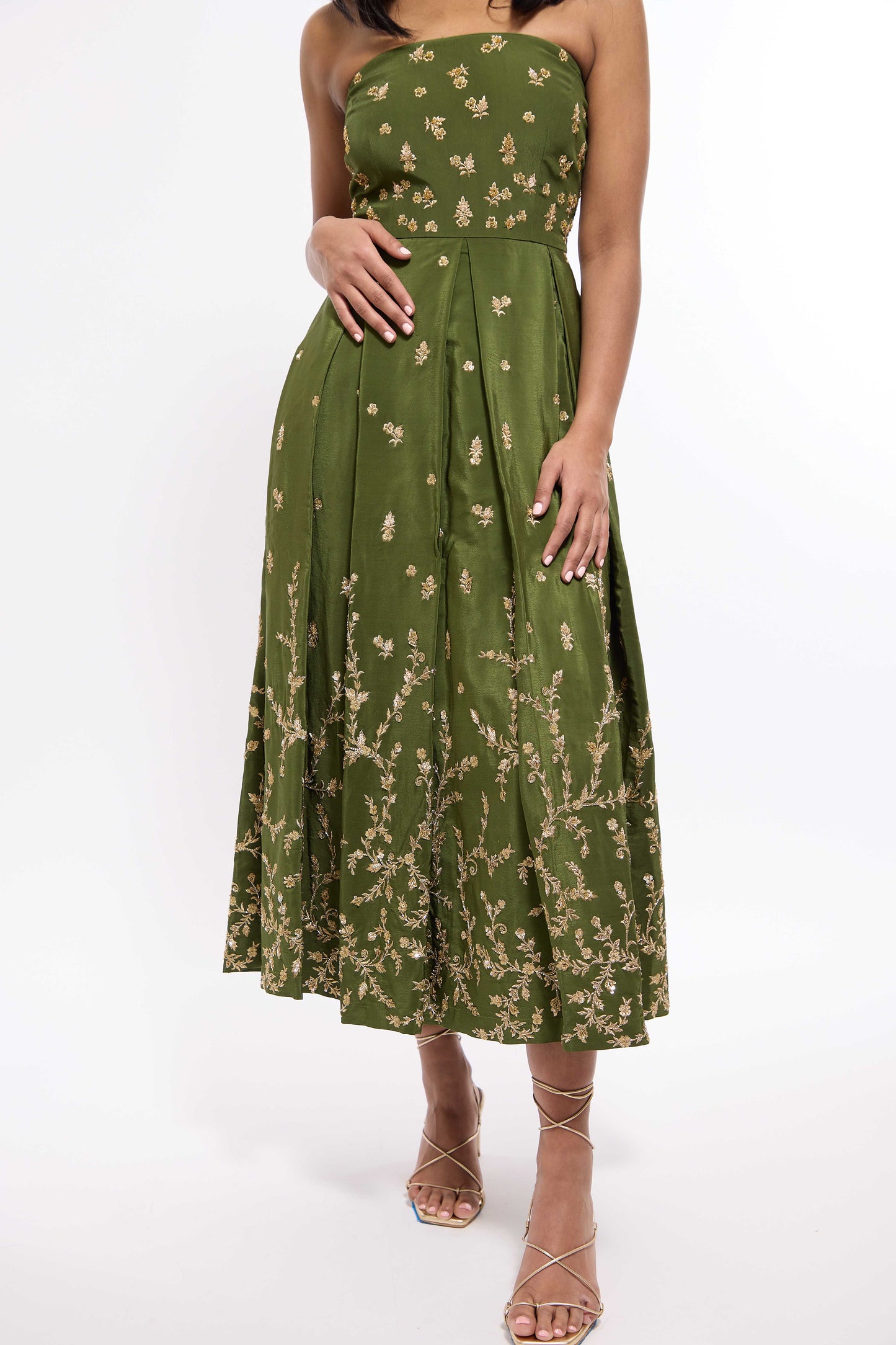 Woman wearing green midi length dress with Indian inspired embroidery