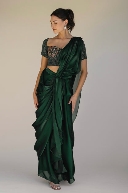 The Adya Drape Saree makes it easy to get the saree look without any pleating and features a shiny organaza skirt with an attached drape + a hand embroidered, bustier top.&nbsp;