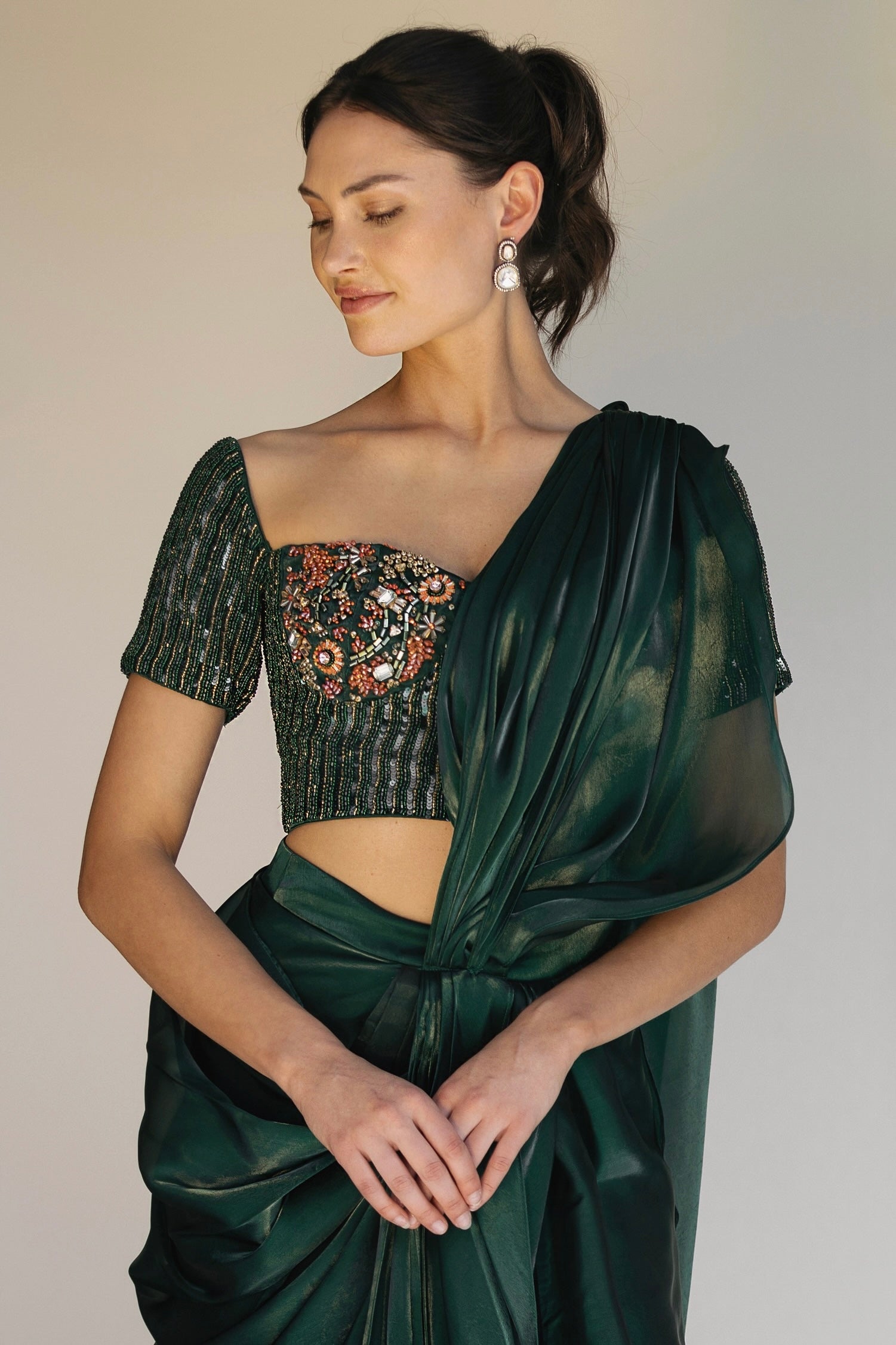 The Adya Drape Saree makes it easy to get the saree look without any pleating and features a shiny organaza skirt with an attached drape + a hand embroidered, bustier top.&nbsp;