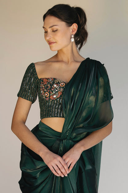 The Adya Drape Saree makes it easy to get the saree look without any pleating and features a shiny organaza skirt with an attached drape + a hand embroidered, bustier top.&nbsp;