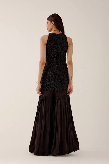 The Anika Gharara is a halter neck, cutwork, hand-embroidered dress paired with bamber satin gharara pants.