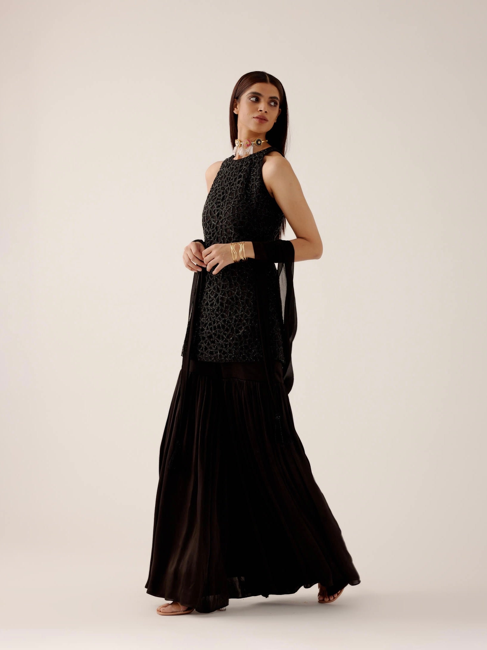 The Anika Gharara is a halter neck, cutwork, hand-embroidered dress paired with bamber satin gharara pants.