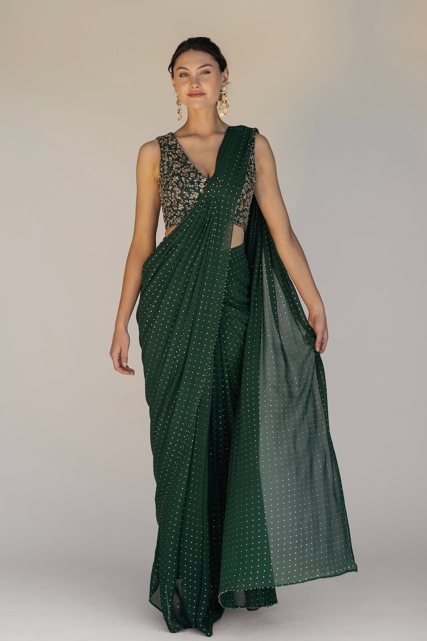 This saree has a hand-embroidered cropped top with intricate beadwork and lustrous sequins and is paired with a skirt featuring attached wraparound draping.