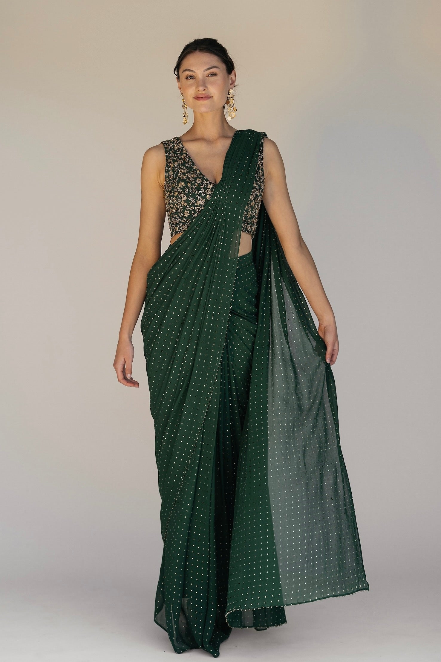 This saree has a hand-embroidered cropped top with intricate beadwork and lustrous sequins and is paired with a skirt featuring attached wraparound draping.