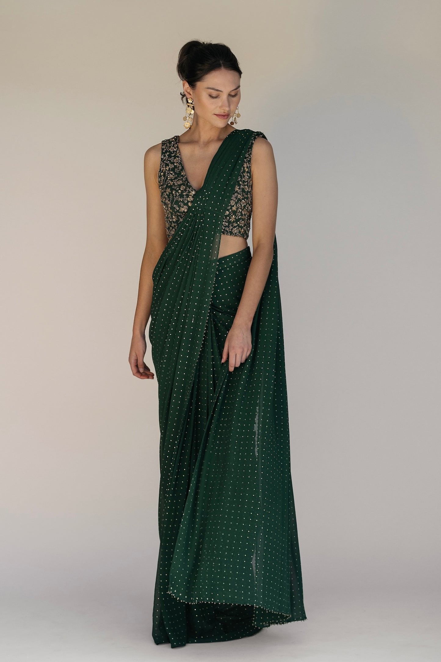 This saree has a hand-embroidered cropped top with intricate beadwork and lustrous sequins and is paired with a skirt featuring attached wraparound draping.