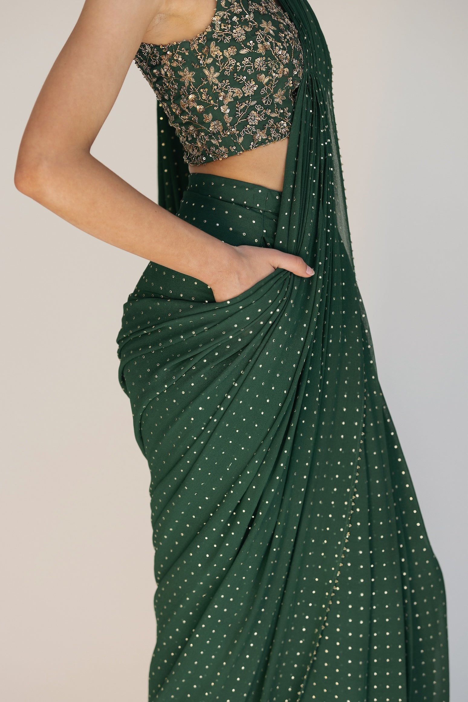 This saree has a hand-embroidered cropped top with intricate beadwork and lustrous sequins and is paired with a skirt featuring attached wraparound draping.