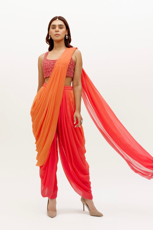 The Asra Dhoti takes the elegance of a saree's drape and combines it with the comfort of a dhoti pant. The&nbsp;ombre drape is attached to the outfit and is paired with hand embroidered blouse.&nbsp;