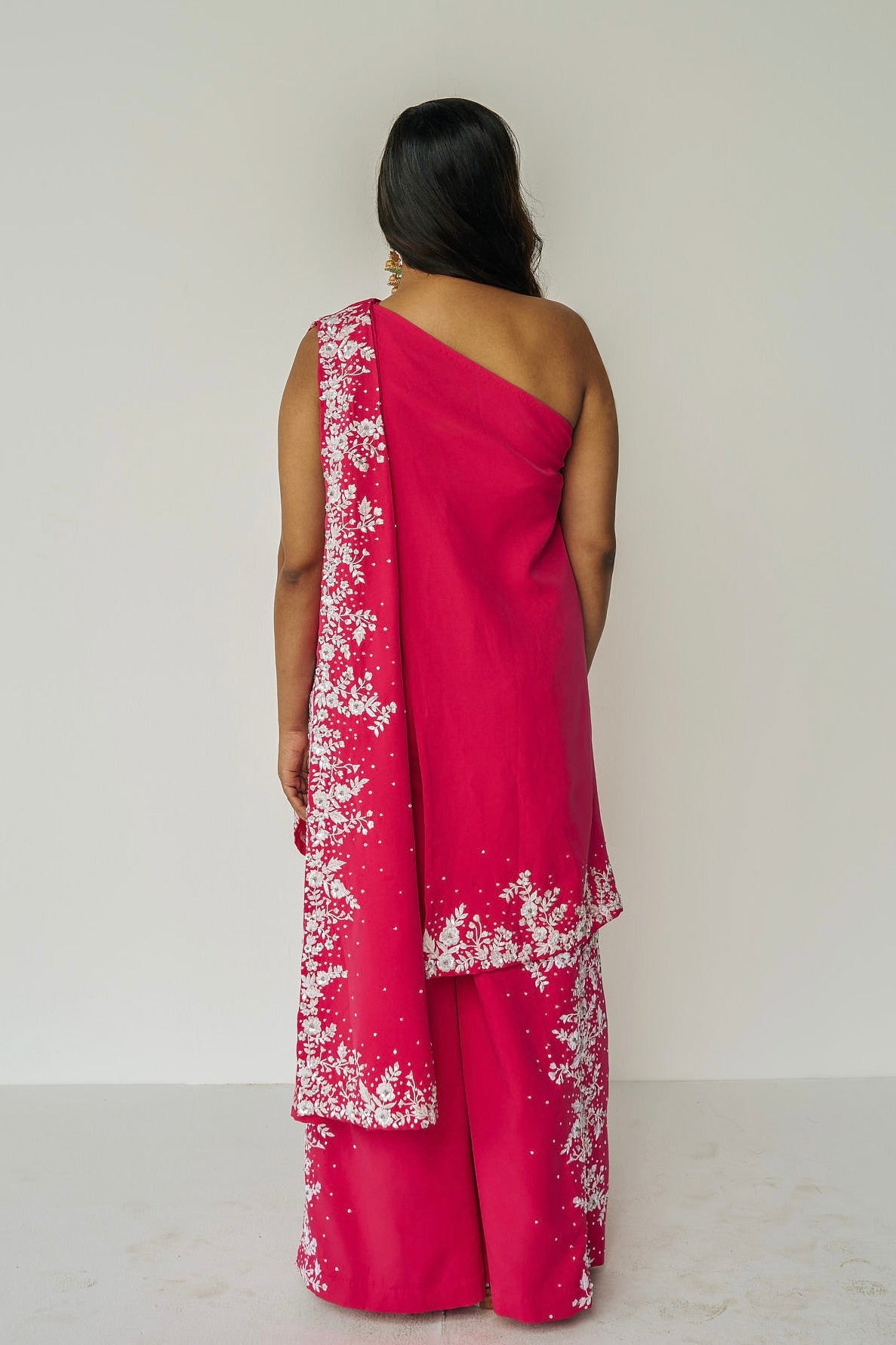 The Cleo Set consists of one shoulder top with hand-embroidered, high-waisted pants, and a detachable drape.