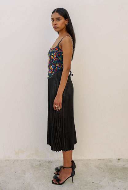 The Zinnia Top is a corset style with embroidered, multicolored flowers and adjustable straps. 