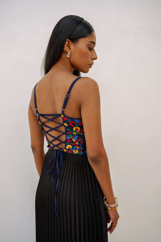 The Zinnia Top is a corset style with embroidered, multicolored flowers and adjustable straps. 