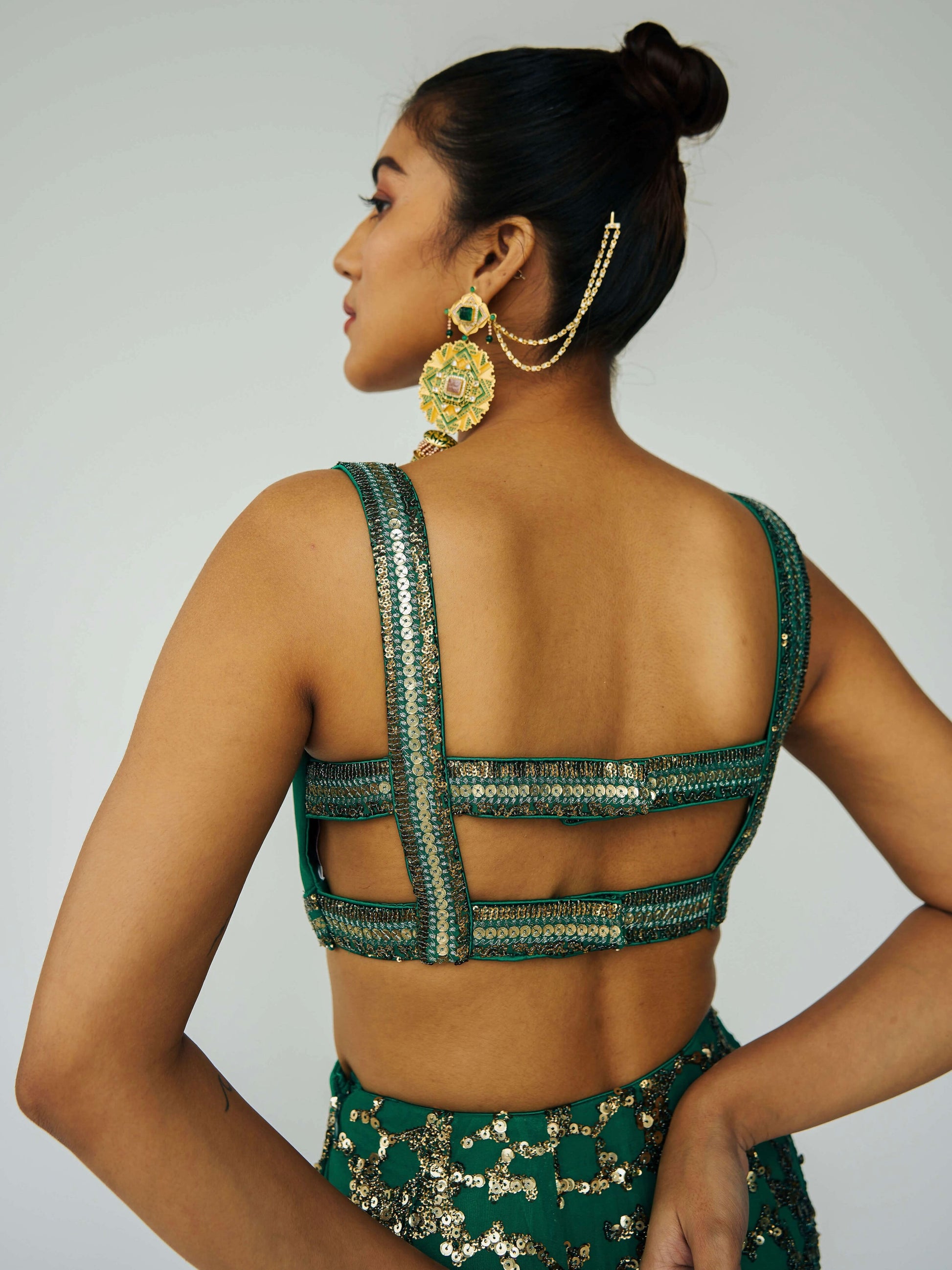The Detachable Lehenga features a sequin-adorned skirt, criss-cross back blouse, a and delicate net dupatta. With a removable portion, it effortlessly transforms into a shorter skirt for a night of dancing.