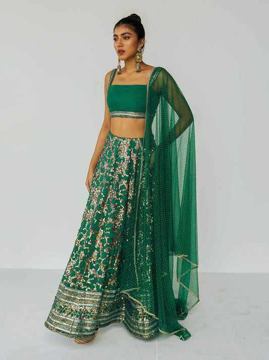 The Detachable Lehenga features a sequin-adorned skirt, criss-cross back blouse, a and delicate net dupatta. With a removable portion, it effortlessly transforms into a shorter skirt for a night of dancing.