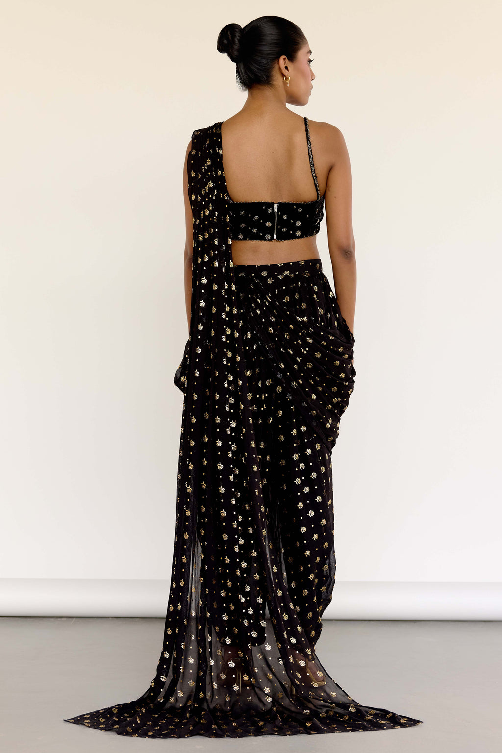 The Farah Dhoti set features a flattering midriff-baring top, flowy dhoti pants made for dancing, and an attached dupatta that drapes perfectly every time—no pleating, no fuss. The gold foil print adds just the right amount of texture and attention to detail.