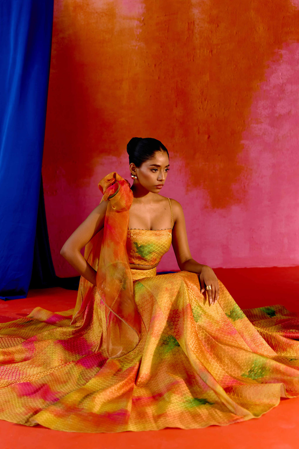 The Holi Lehenga features a printed brocade top with embroidered straps, a high-waisted skirt, and a lightweight printed organza dupatta. An easy lehenga for any celebration.