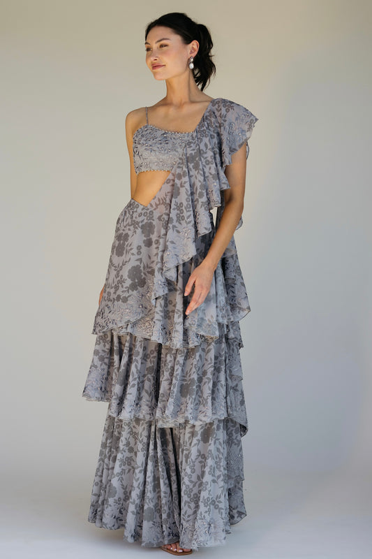The Leela Palazzo featured a floral print with hand embroidered accents throughout. The look includes a pant with rufflied tiers and a dupatta, which are both paired back to a hand embroidered blouse with silver detailing.&nbsp;