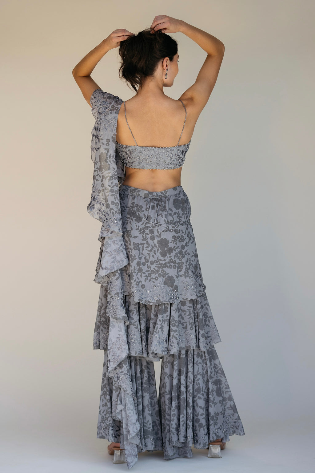 The Leela Palazzo featured a floral print with hand embroidered accents throughout. The look includes a pant with rufflied tiers and a dupatta, which are both paired back to a hand embroidered blouse with silver detailing.&nbsp;