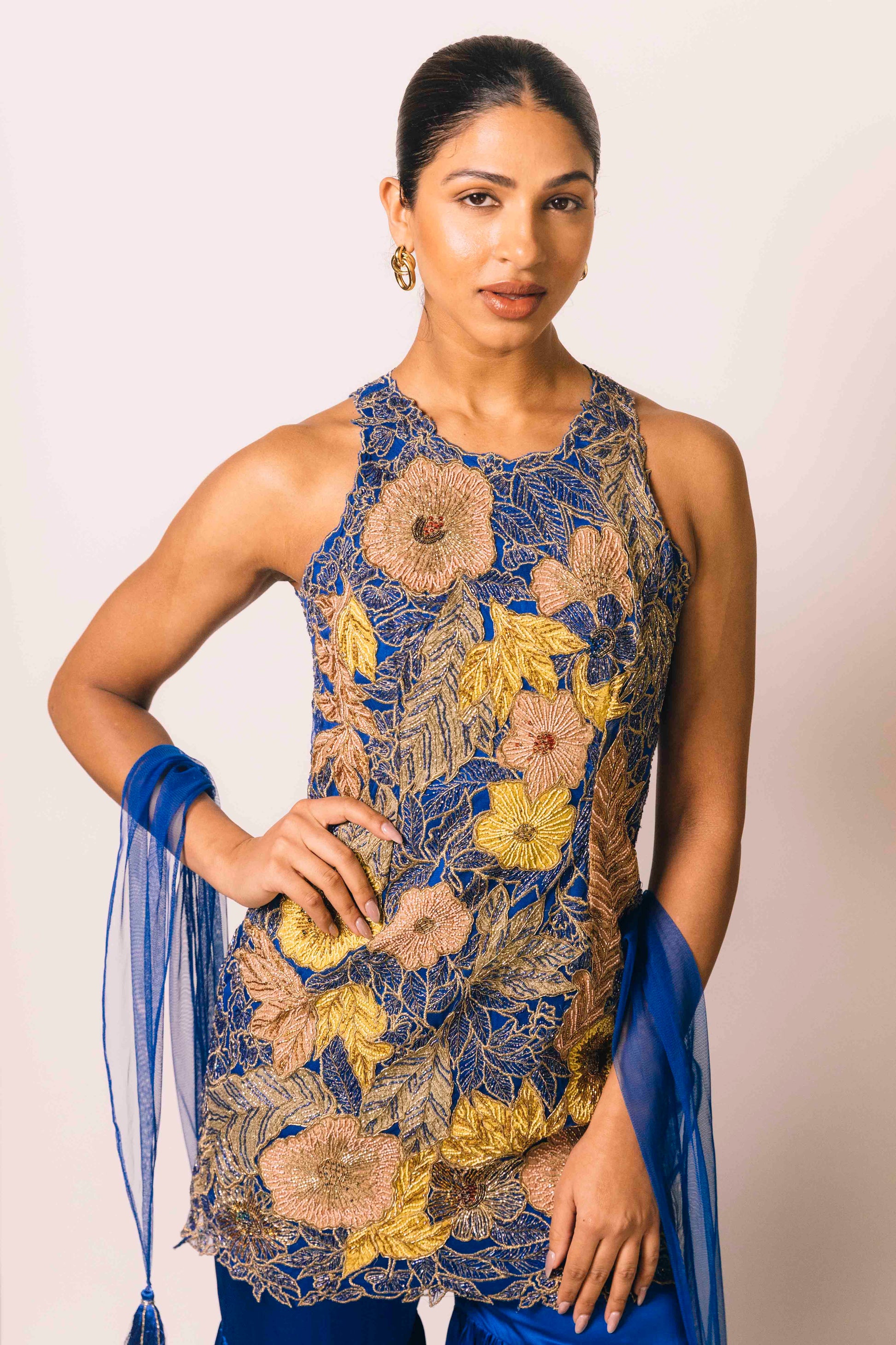 The Nidhi Gharara features intricate floral sequin work throughout the hand-embroidered mini dress, paired with silky gharara pants and a skinny dupatta. The outfit ALSO can be worn as a mini dress.