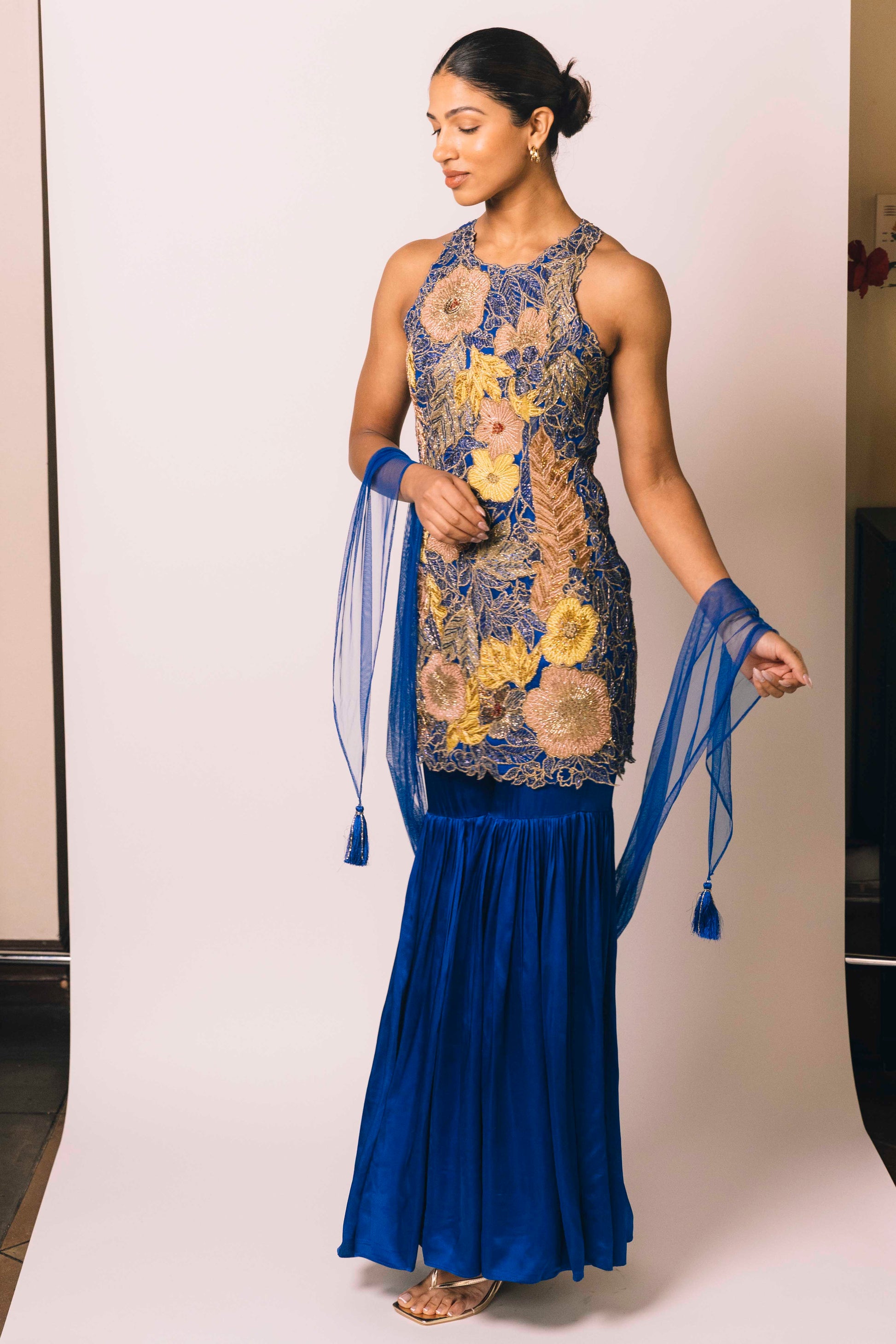 The Nidhi Gharara features intricate floral sequin work throughout the hand-embroidered mini dress, paired with silky gharara pants and a skinny dupatta. The outfit ALSO can be worn as a mini dress.