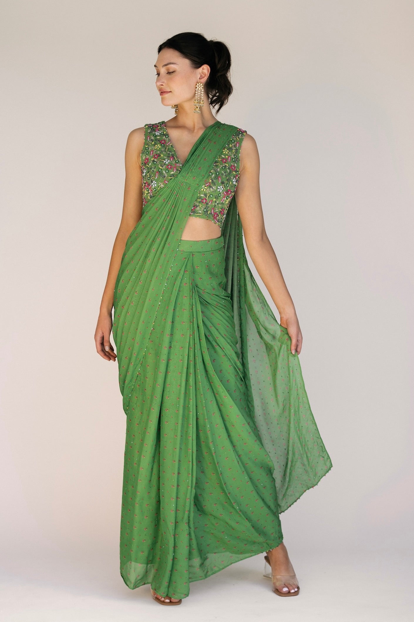 This saree has a hand-embroidered cropped top with intricate beadwork and sequins and is paired with a skirt featuring attached wraparound draping. This outfit is prestitched, so you can put it together in 30 seconds or less.