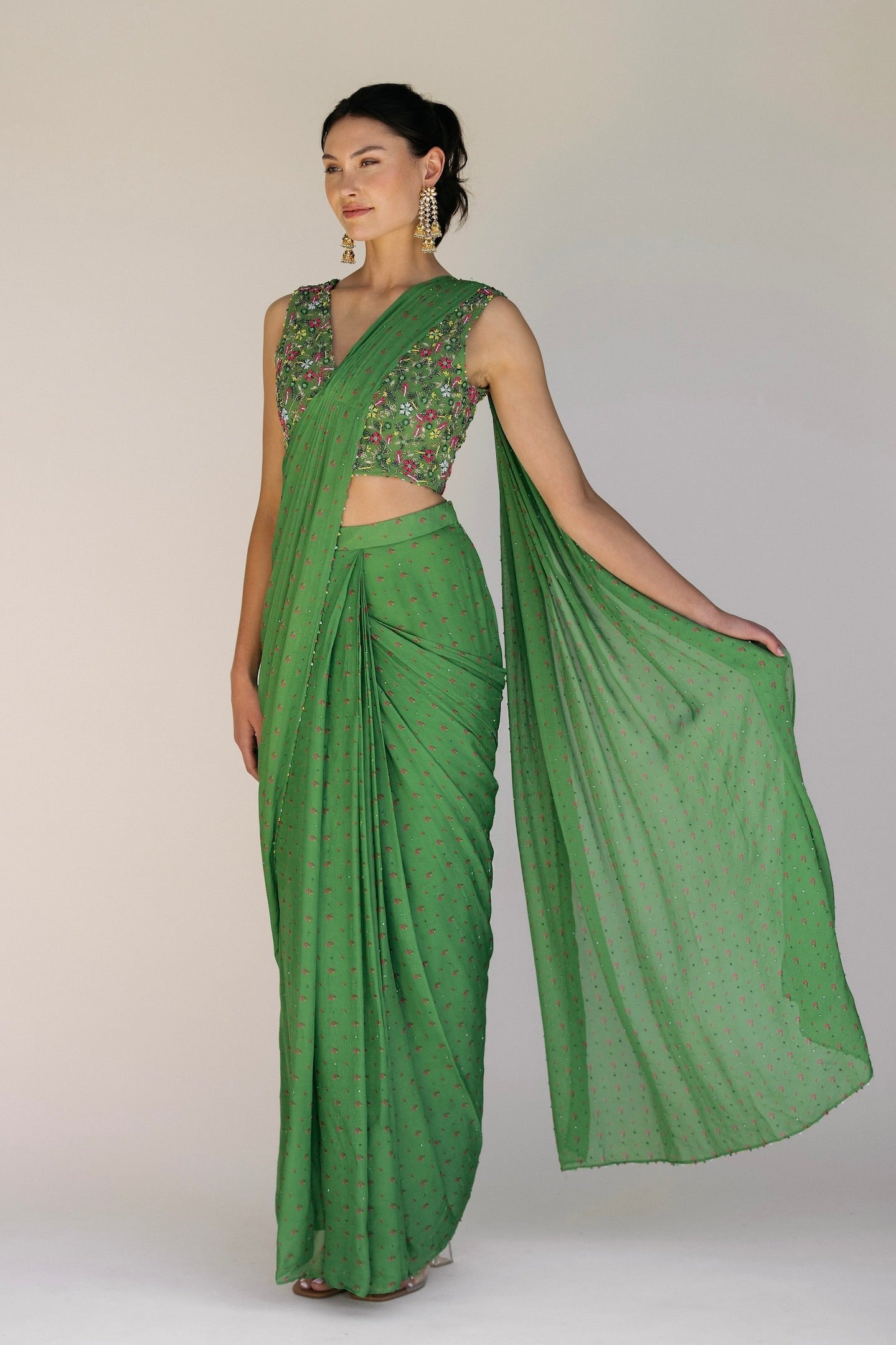 This saree has a hand-embroidered cropped top with intricate beadwork and sequins and is paired with a skirt featuring attached wraparound draping. This outfit is prestitched, so you can put it together in 30 seconds or less.